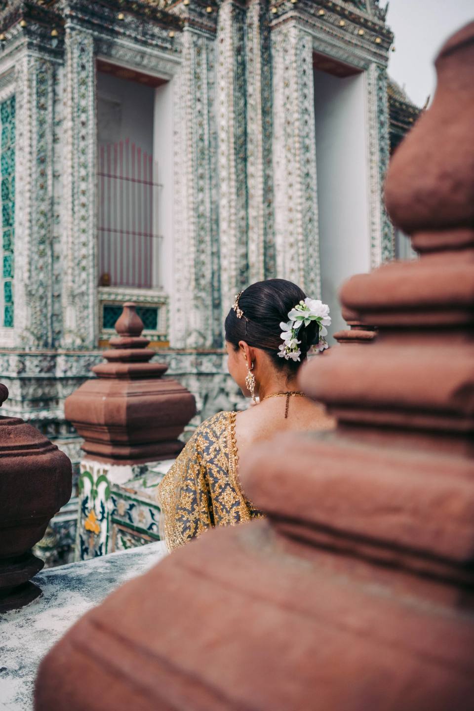 A person framed between richly detailed temple columns.