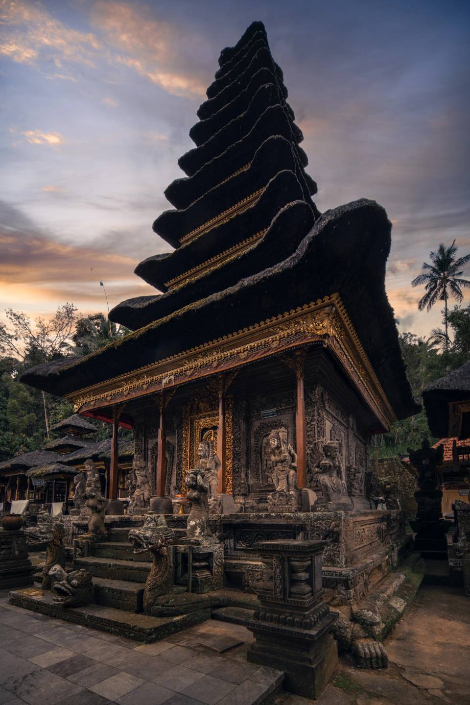 A tiered temple roof silhouetted against an evening sky.