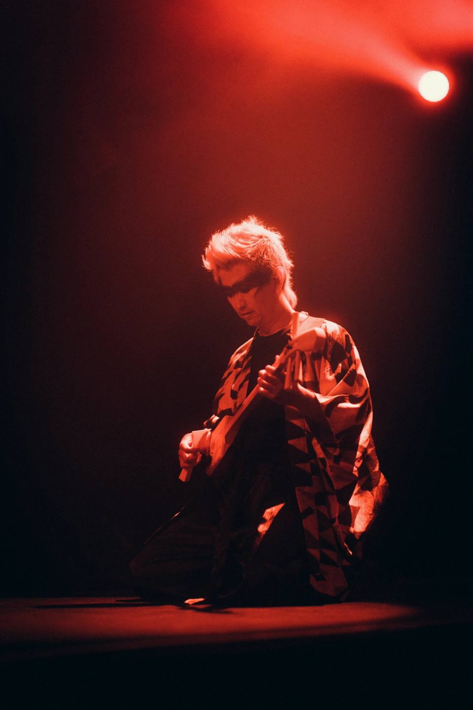 Japanese man playing acoustic instrument