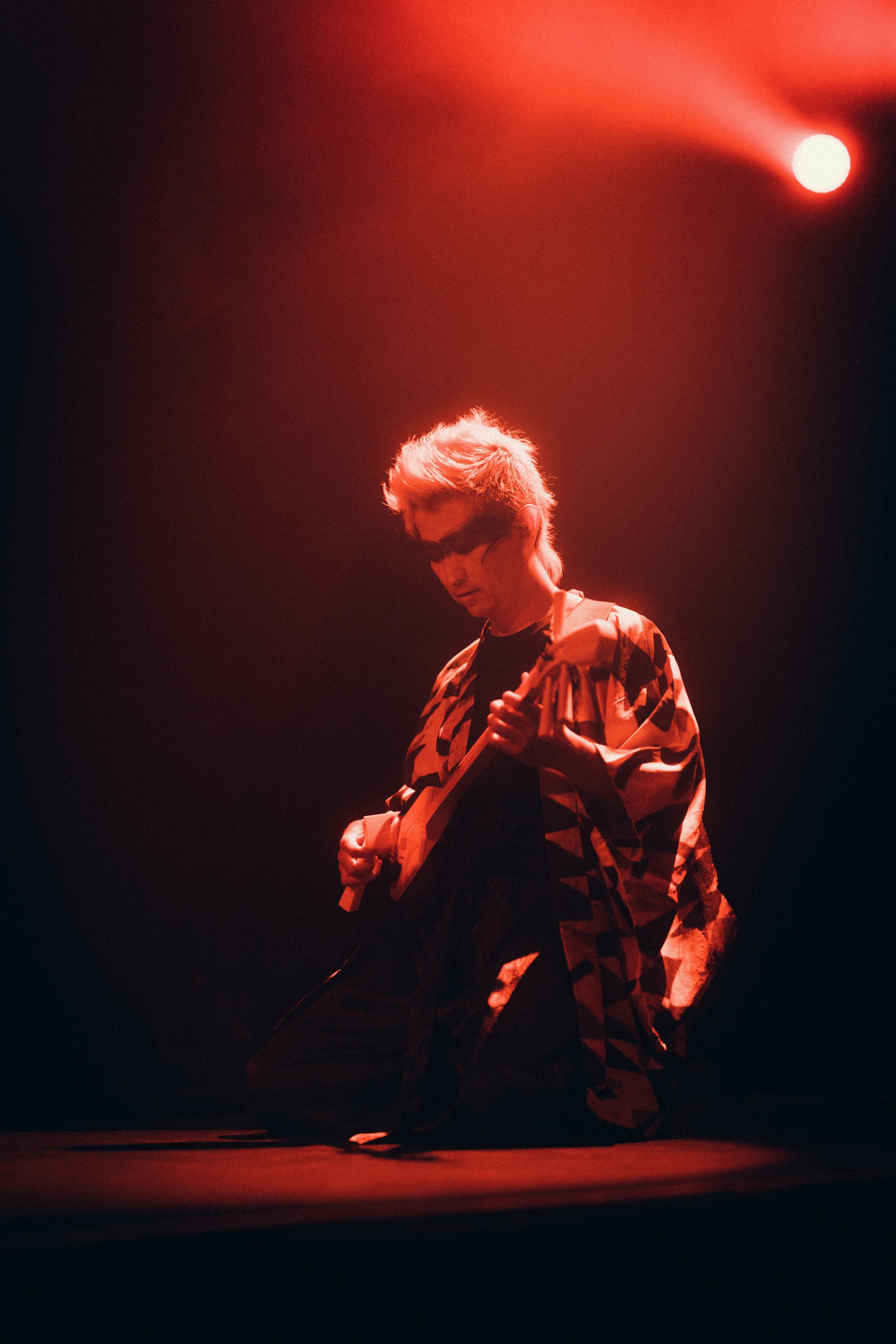Japanese man playing acoustic instrument