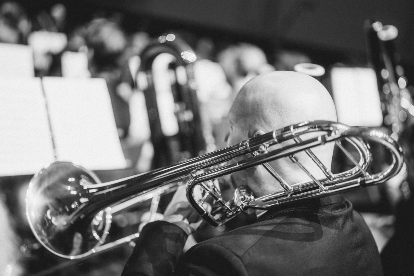 A close view of a trombonist playing among orchestral musicians, in black and white. Australian Doctors Orchestra 2026, Adelaide.
