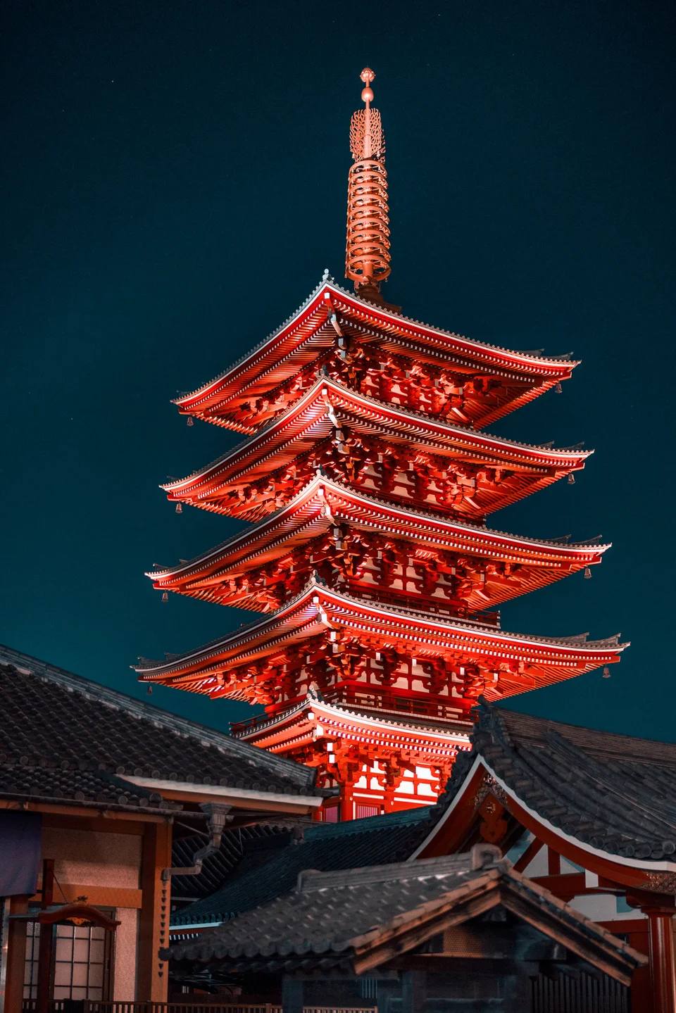 A red pagoda illuminated against the night sky.