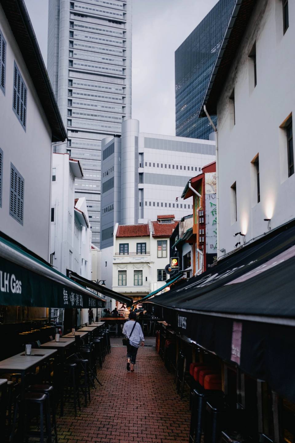 A narrow pedestrian street between traditional and modern buildings.