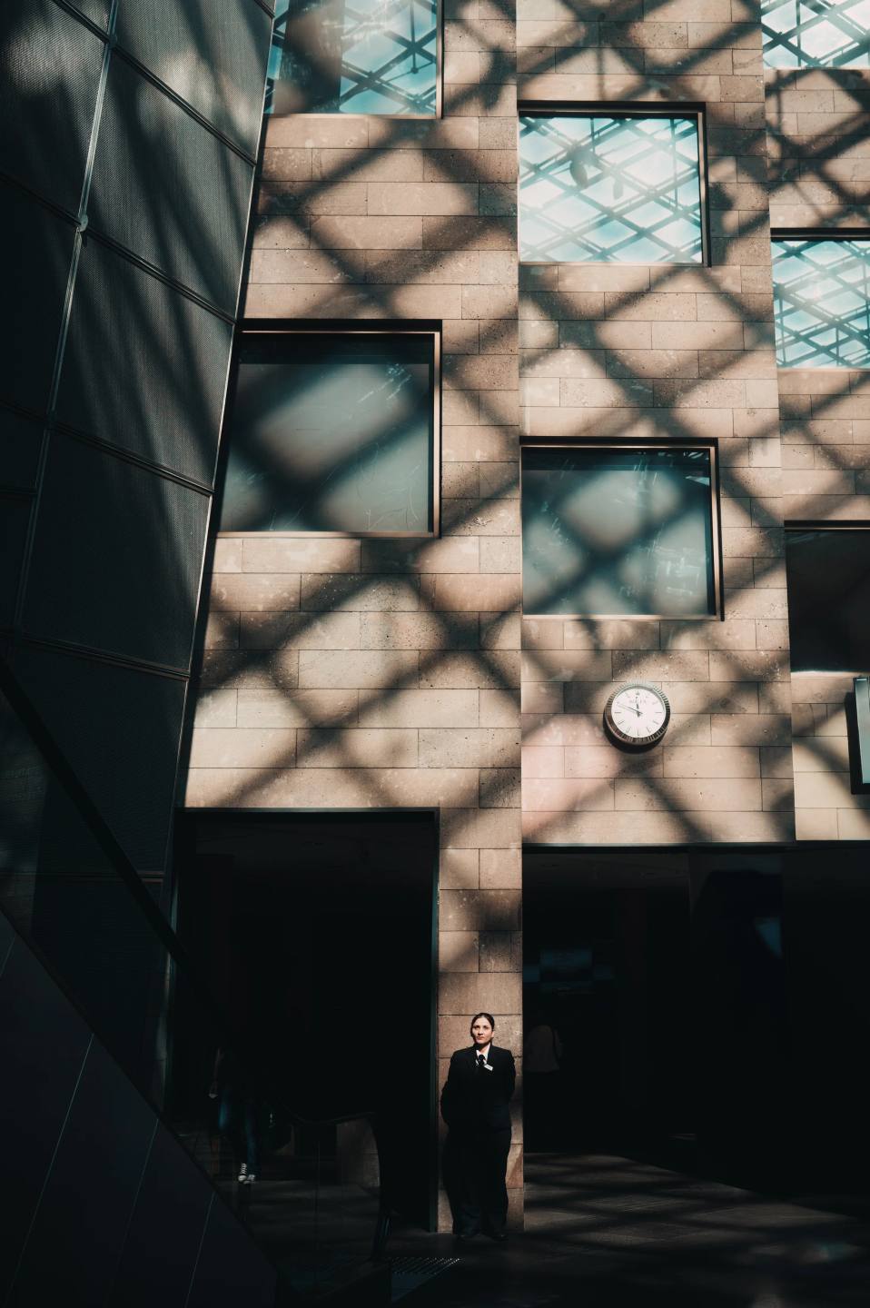 Geometric shadows cast across a tall gallery wall.
