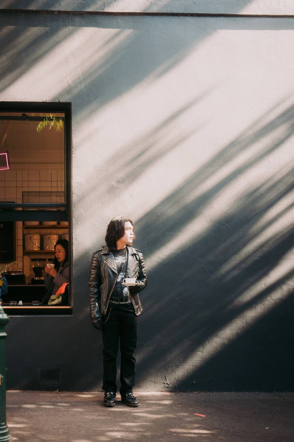 man holding coffee gazing with sun rays on his face