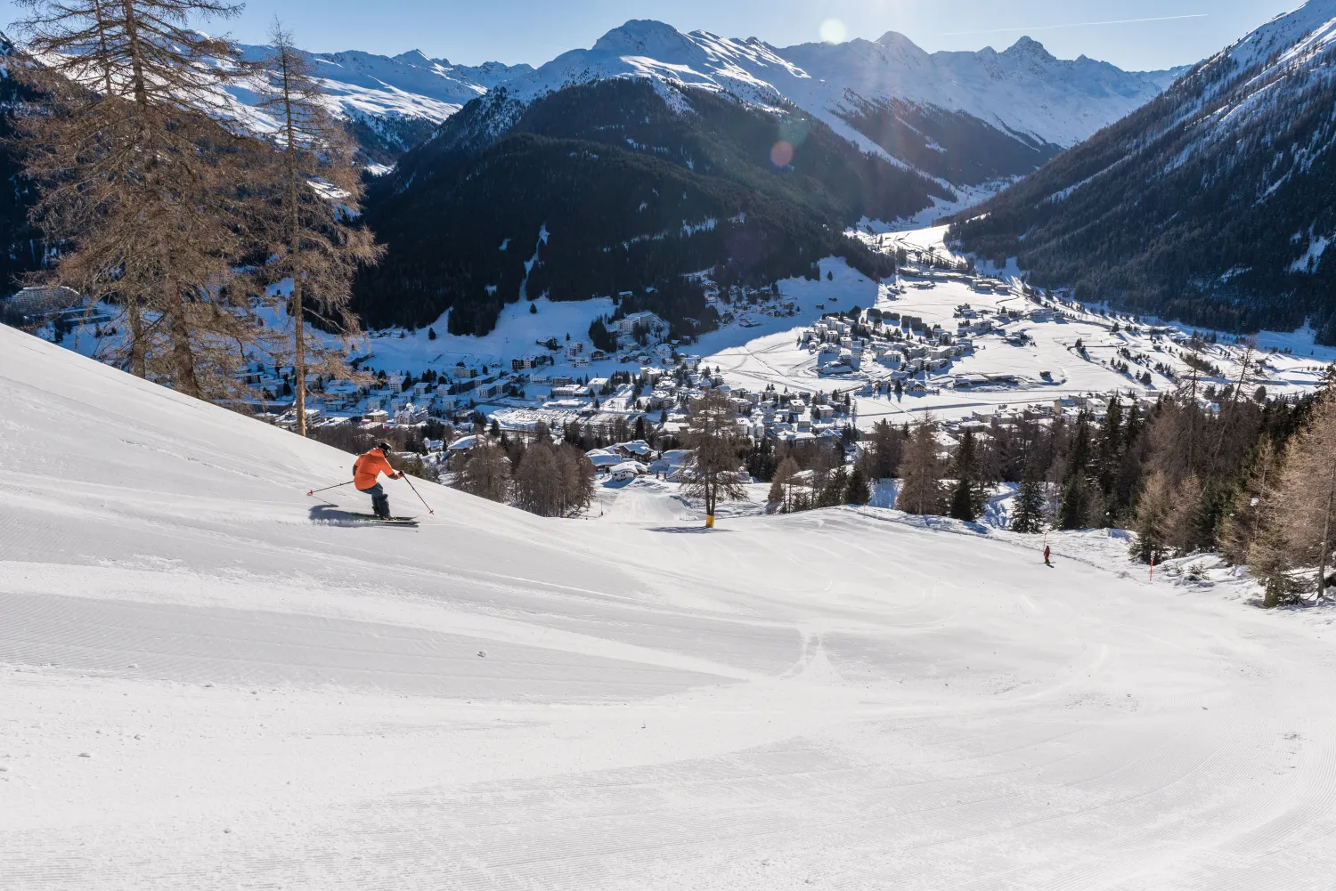 Talfahrt im Winter nach Davos Stadt Berge Schnee Aussicht Skifahrer auf der Piste