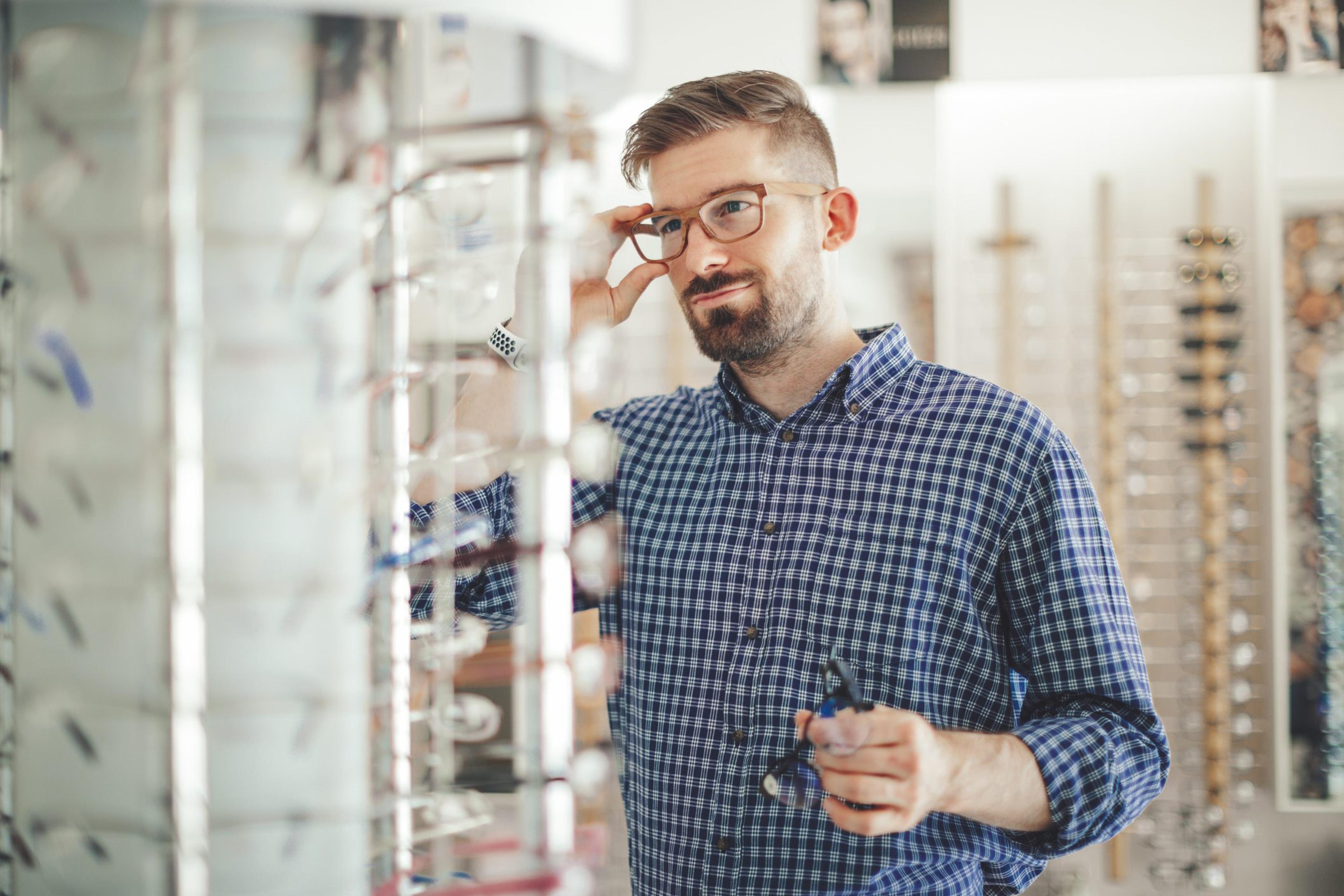Man tries on glasses at the store and uses his Health Savings Account to buy them