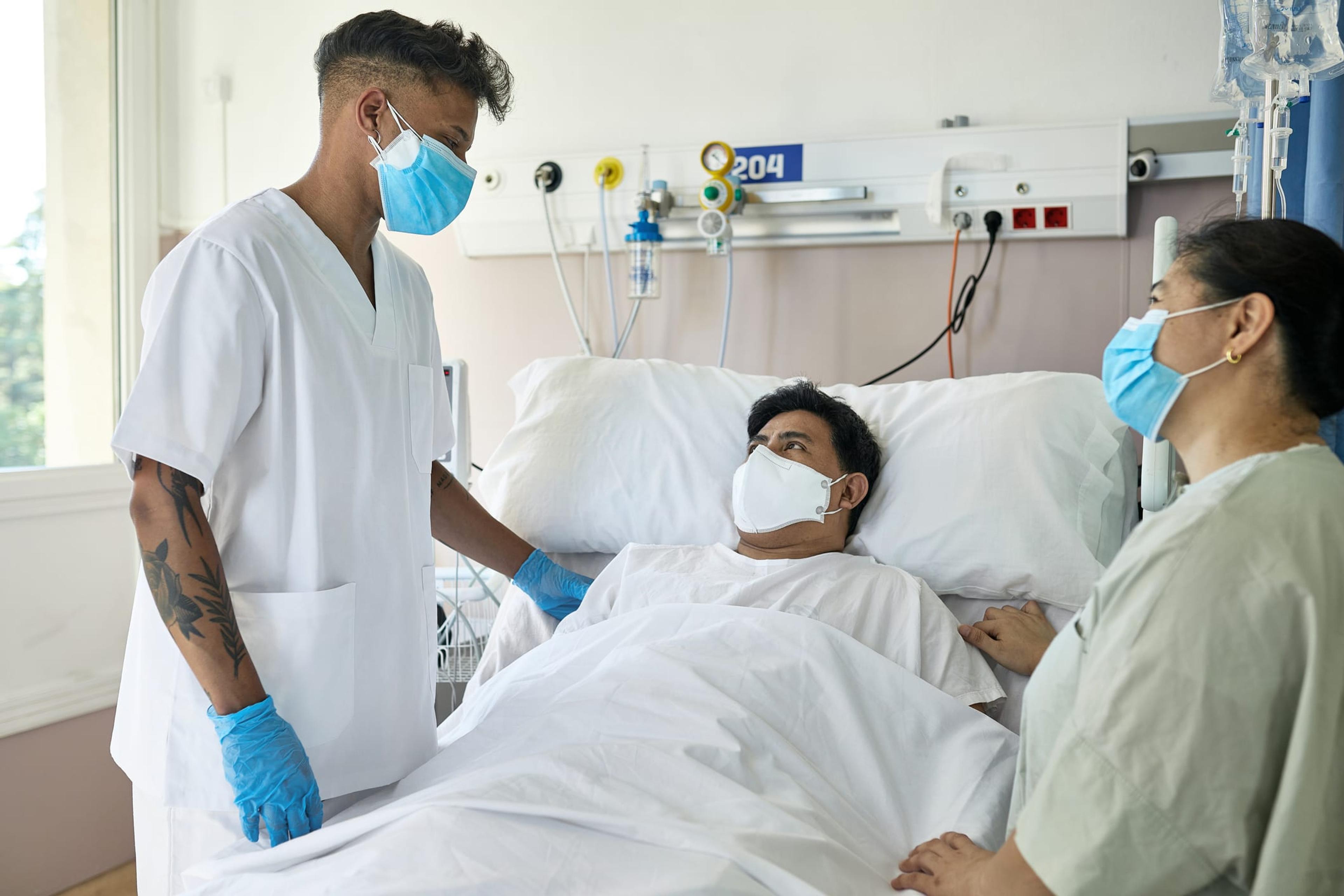 Young Male Nurse at Bedside of Recovering COVID-19 Patient