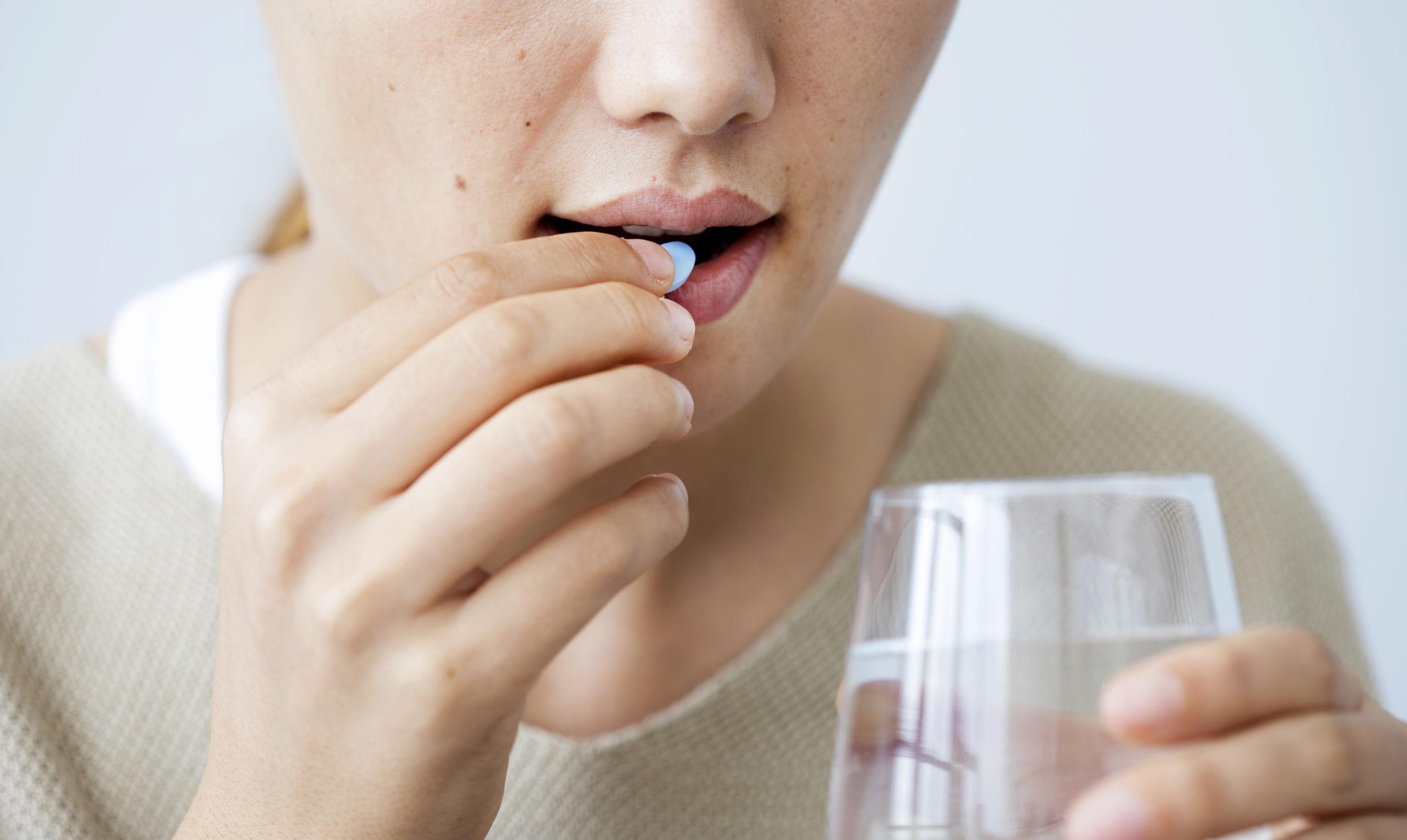 Young woman taking a pill