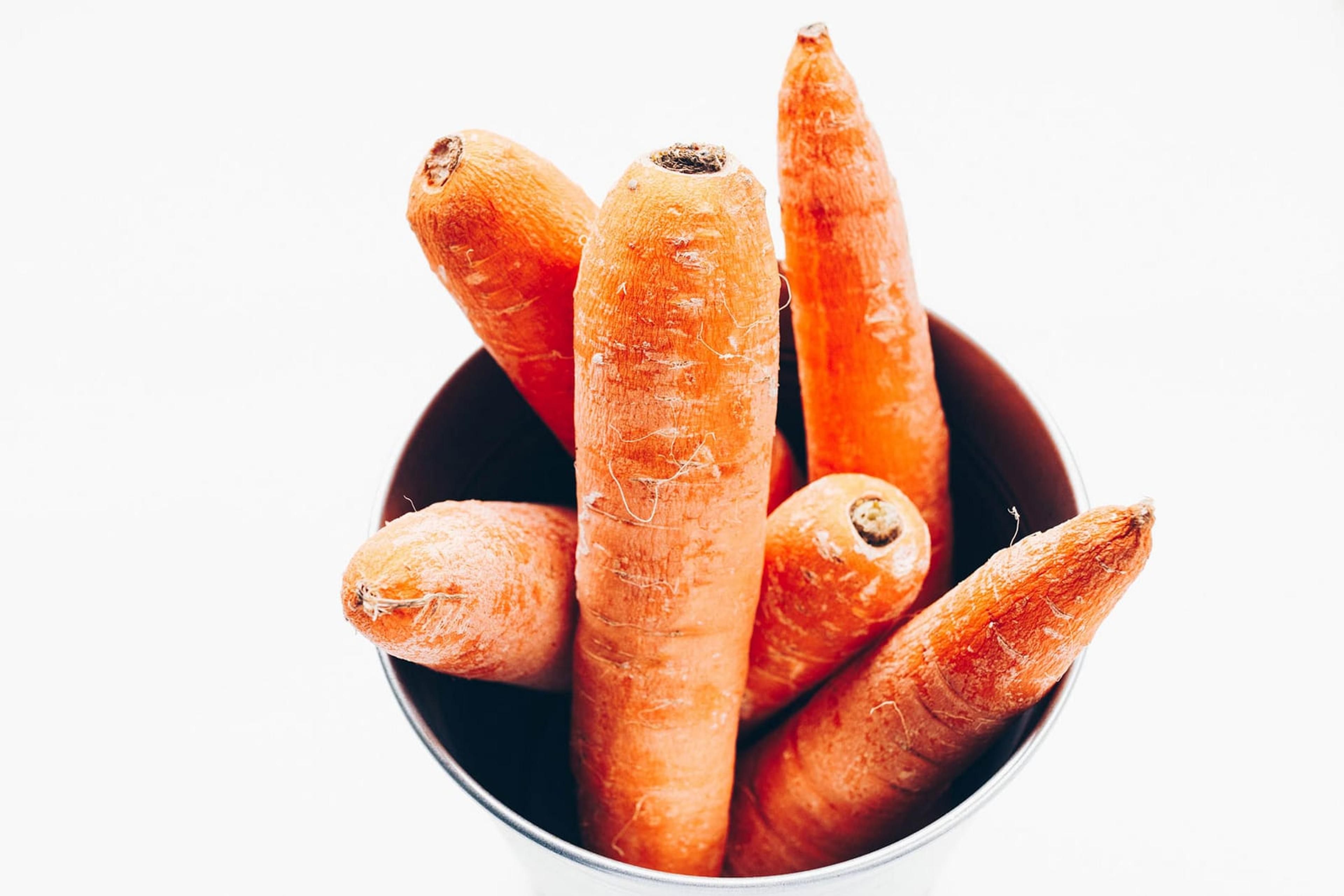 Image of whole carrots in bowl taken from above.