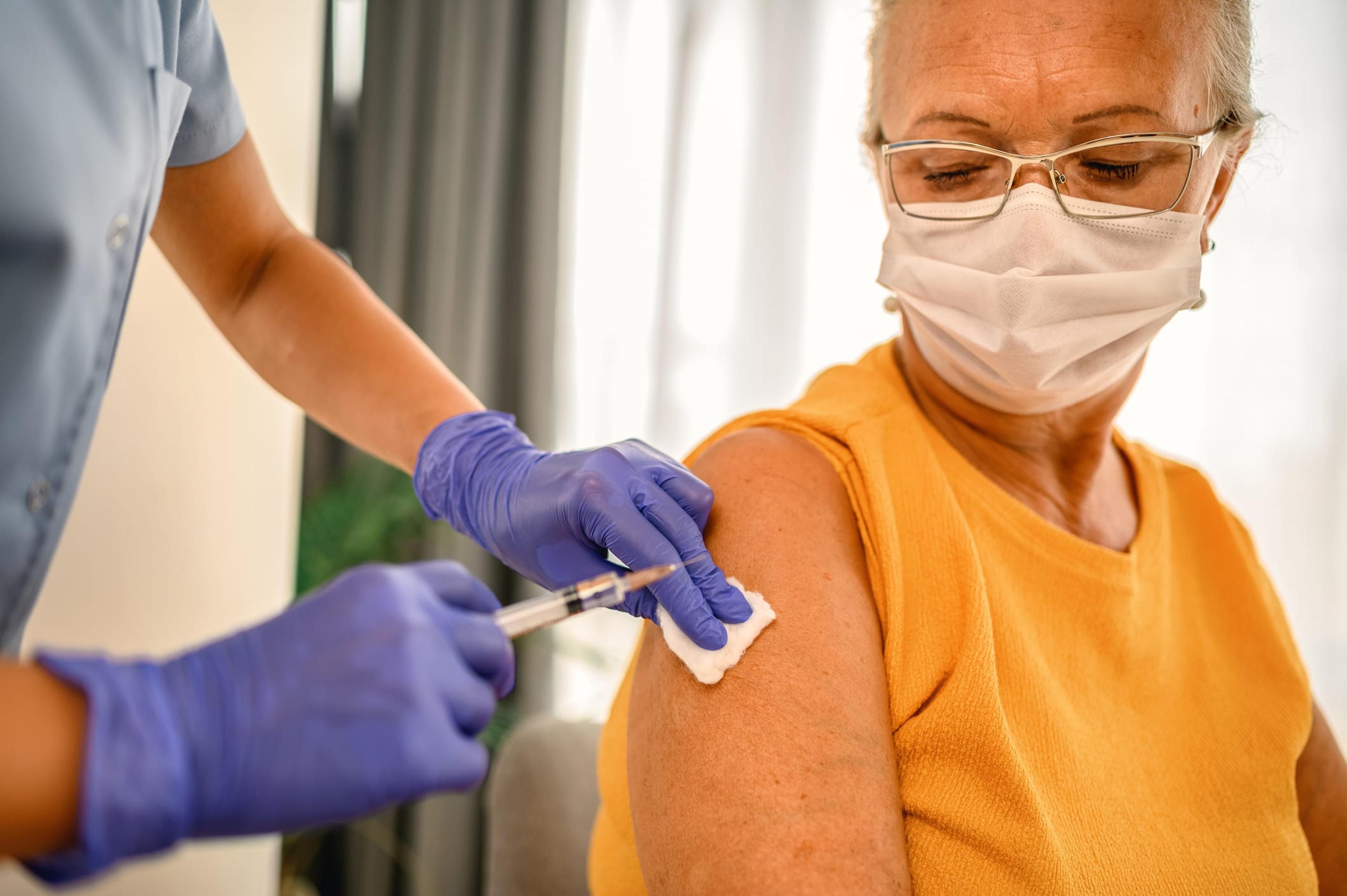 Woman wearing a mask receiving a vaccine
