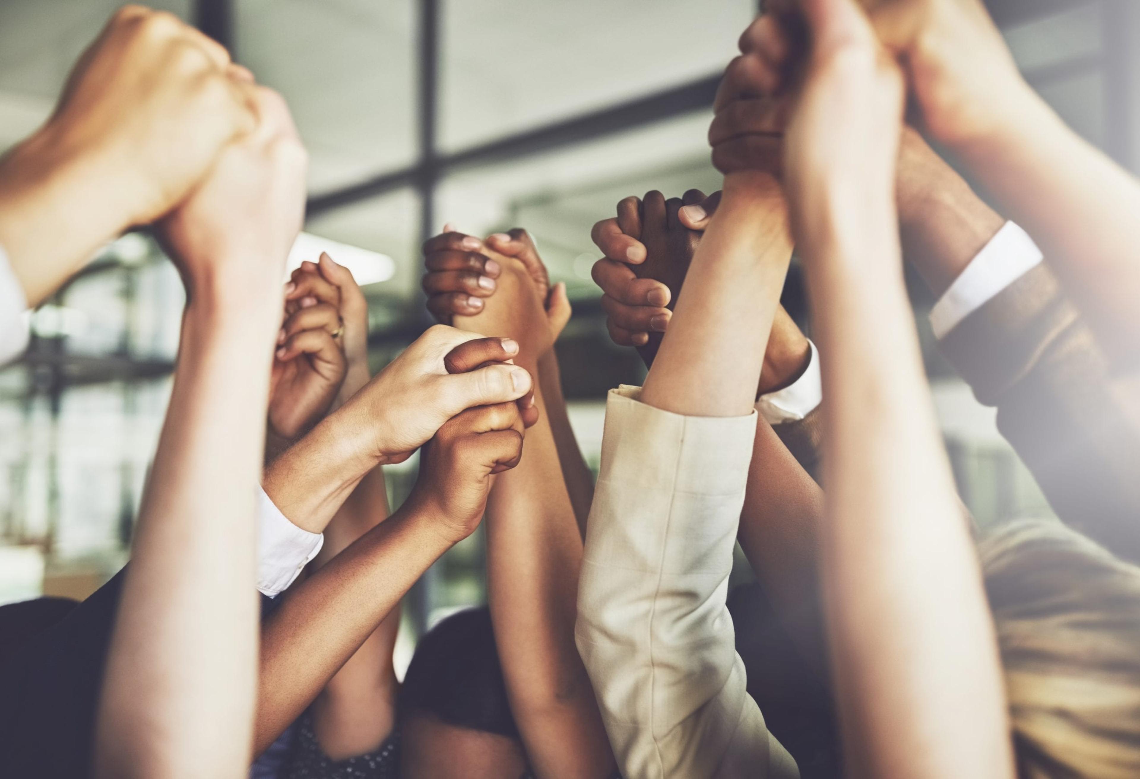 Diverse hands raised together