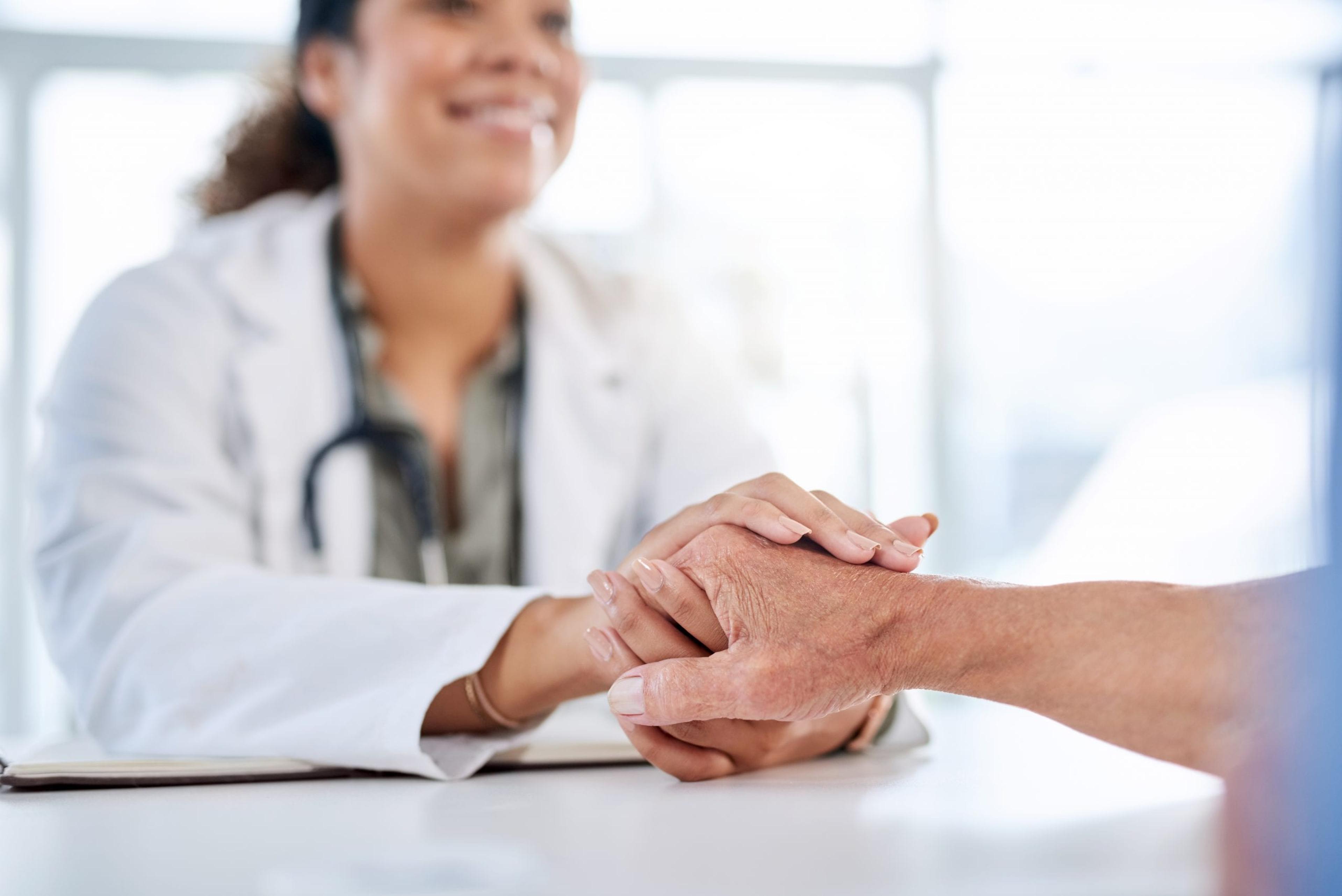 Doctor holding the hand of a patient.