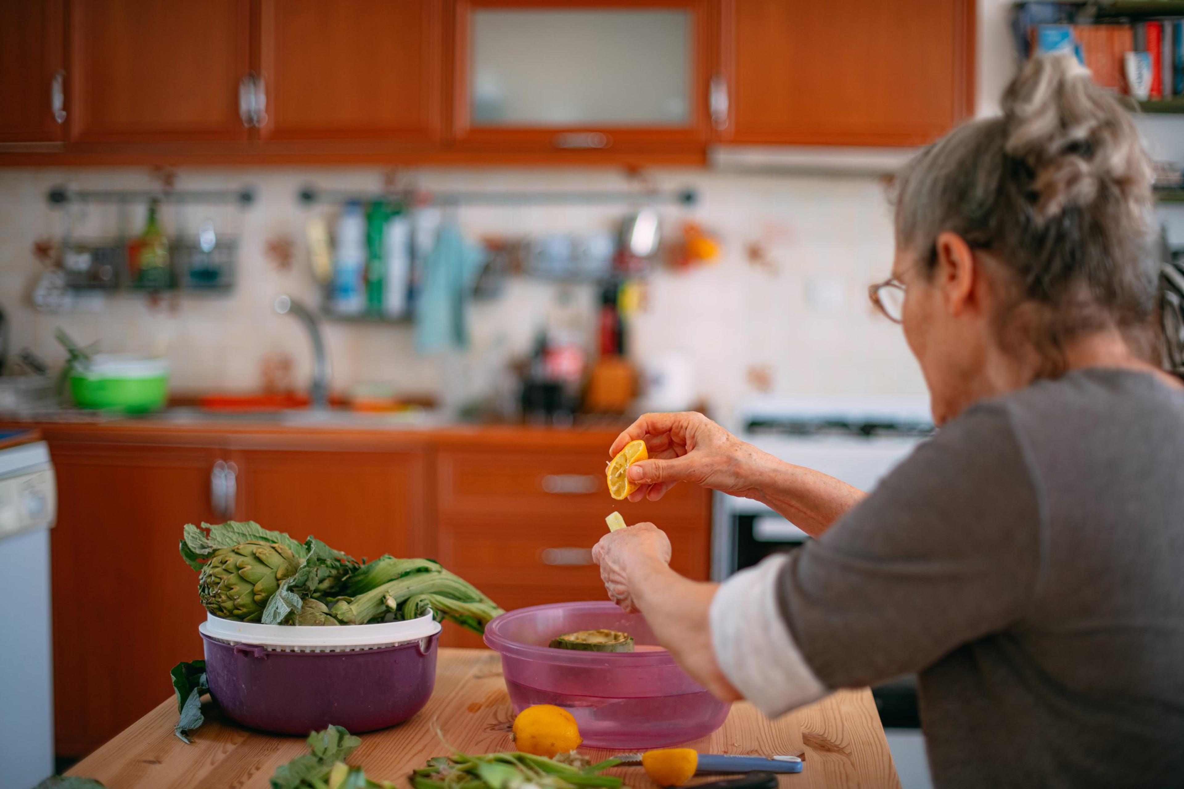 Woman works in the kitchen with fresh prebiotic and probiotic foods