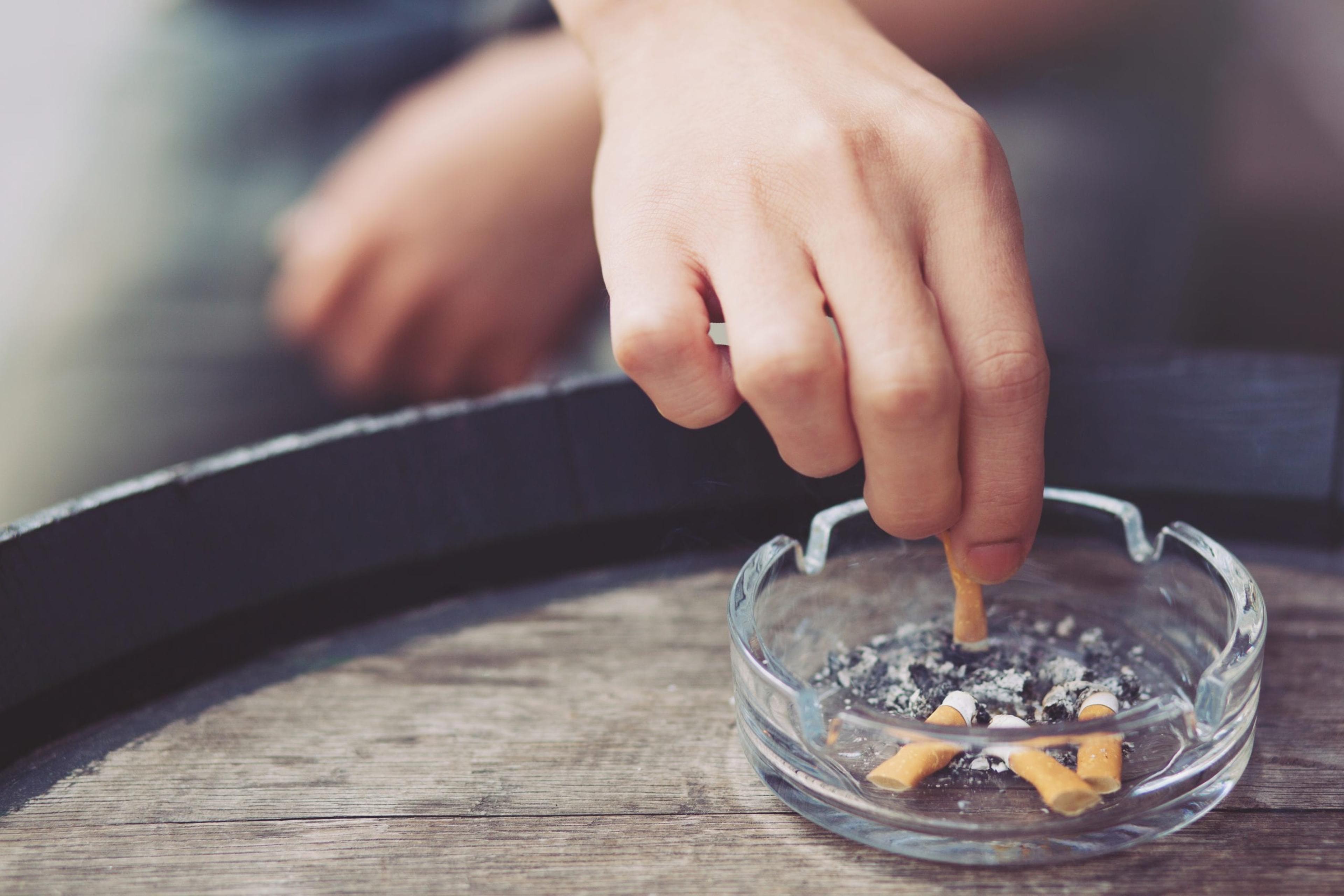 Hand putting out cigarette in an ashtray