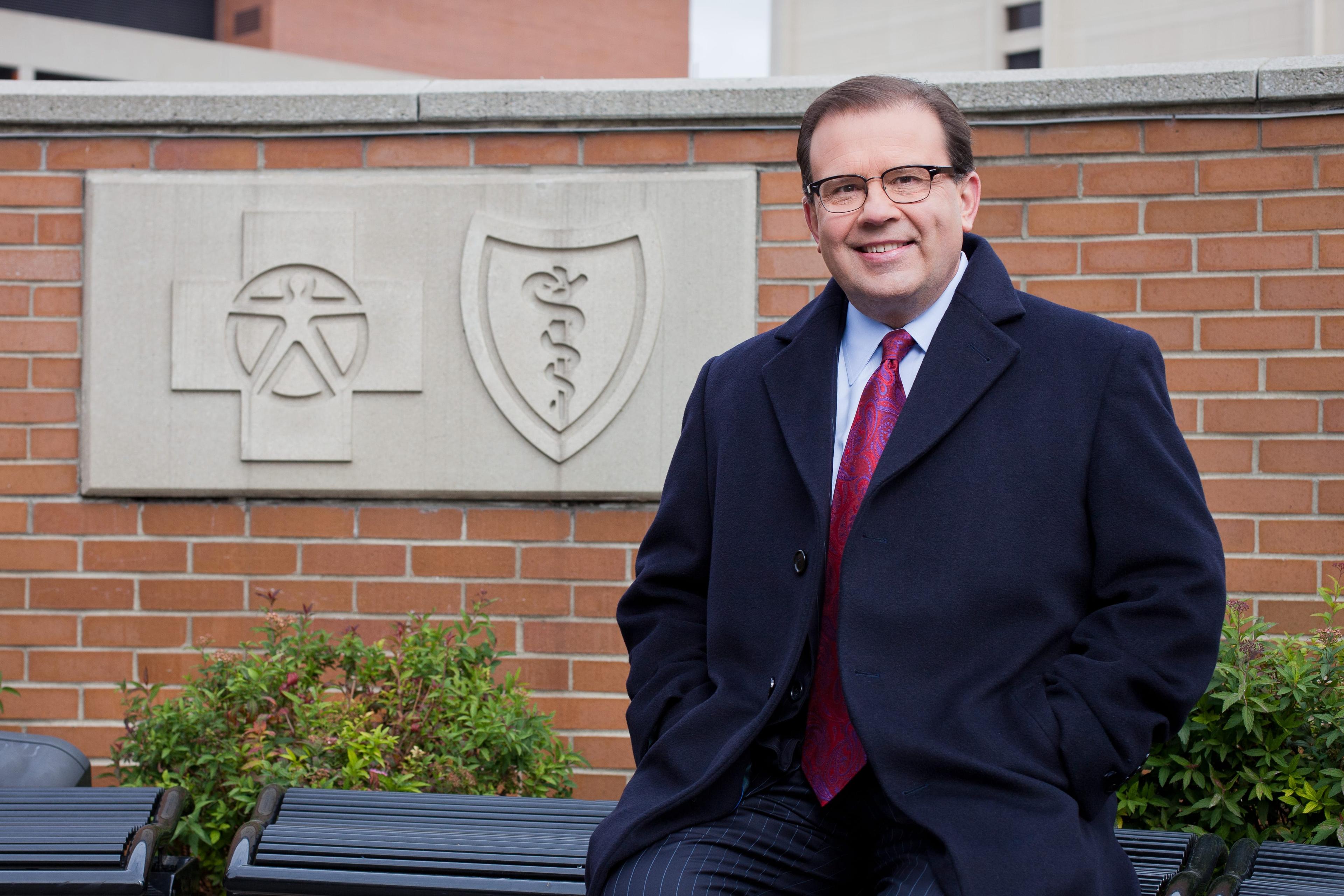 Dan Loepp in front of the Blue Cross Blue Shield of Michigan logo