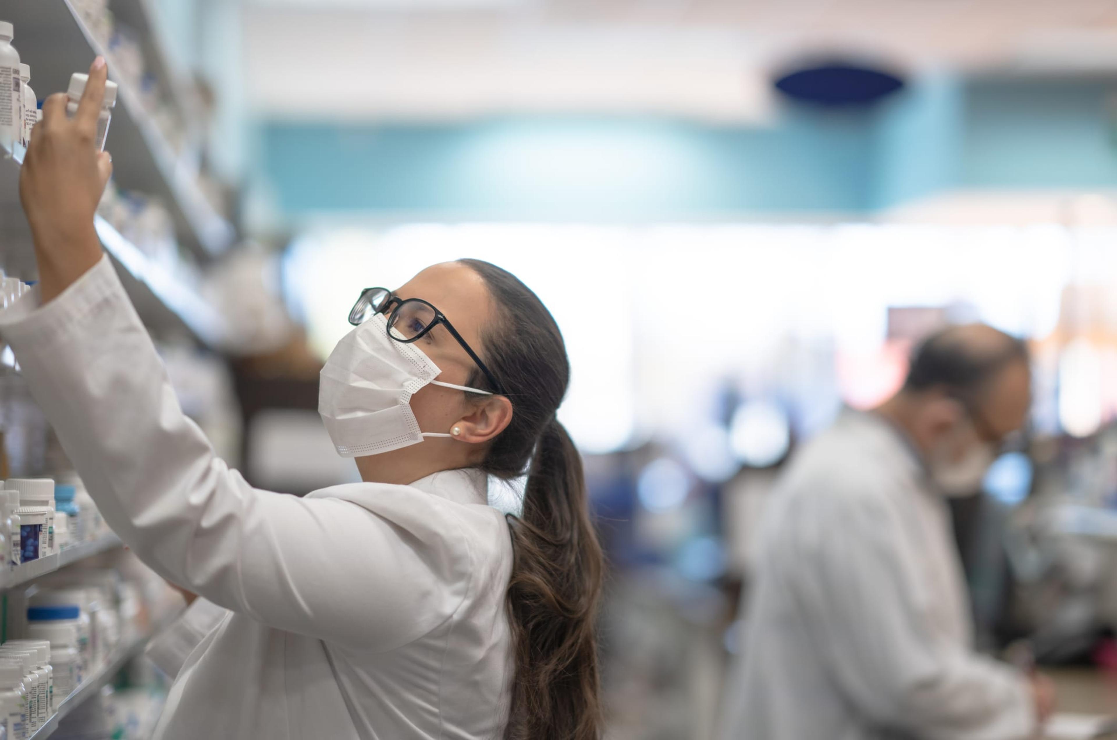 Hispanic female pharmacist looking at medication