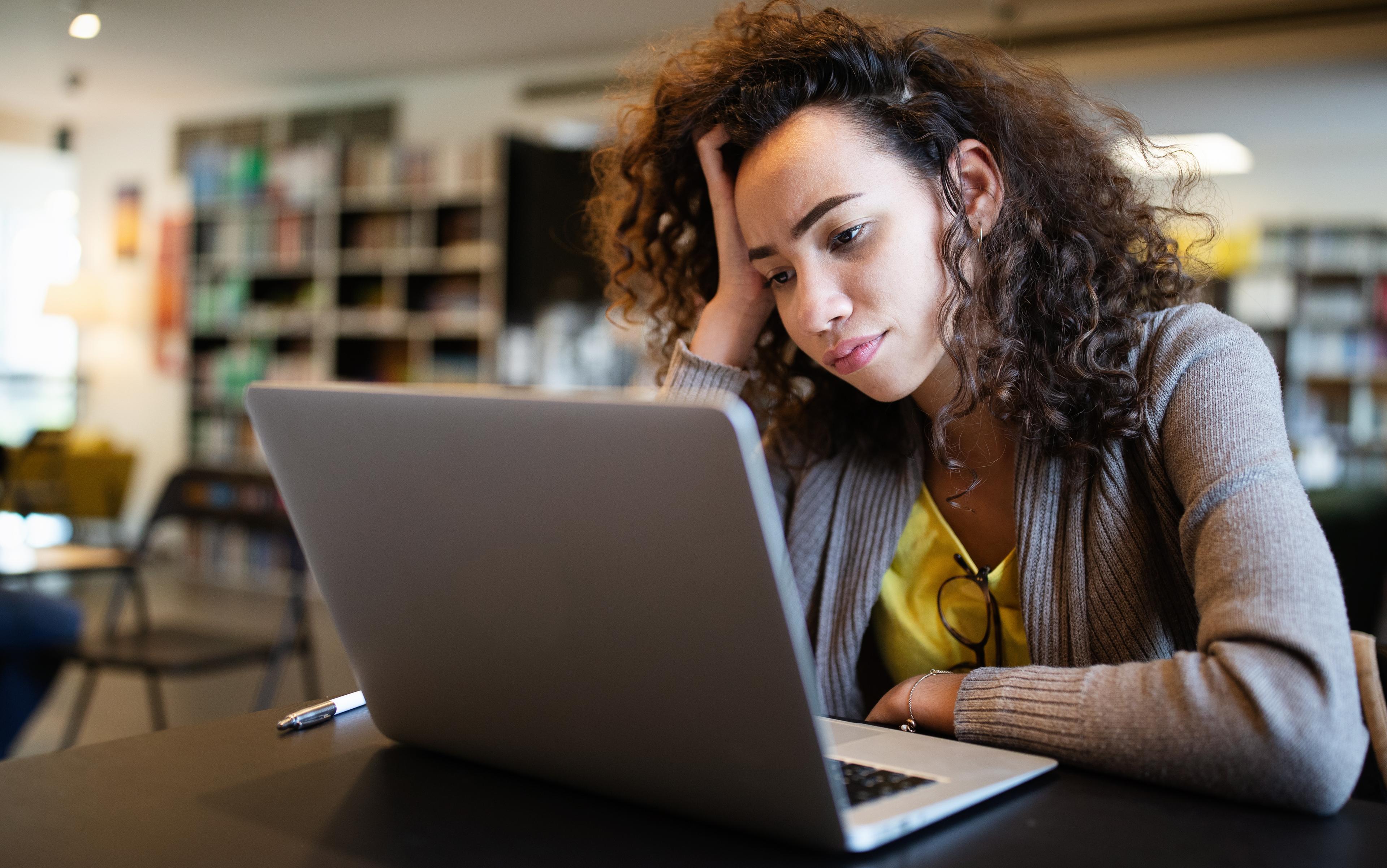 Woman looks at laptop