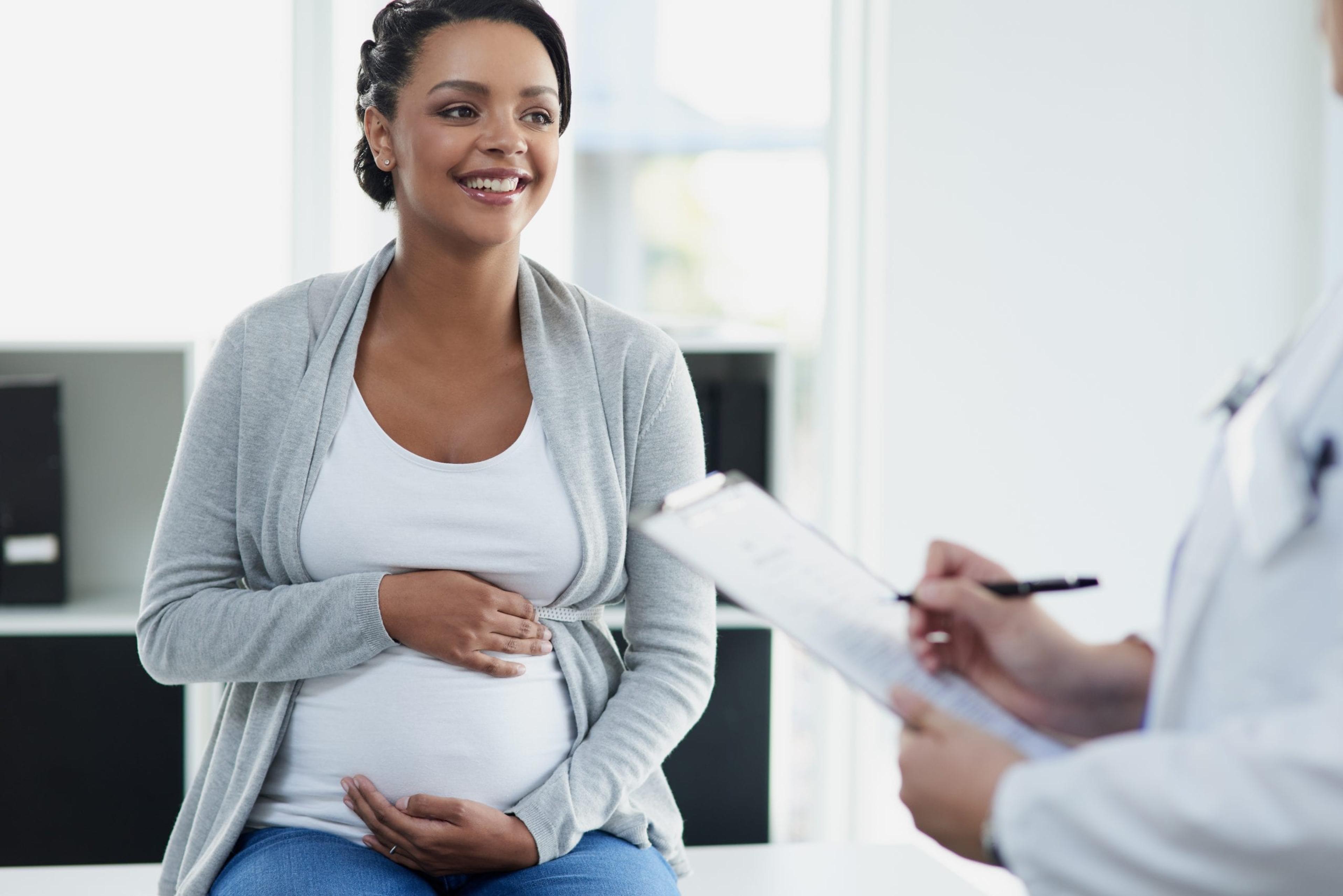 pregnant woman smiling at doctors office