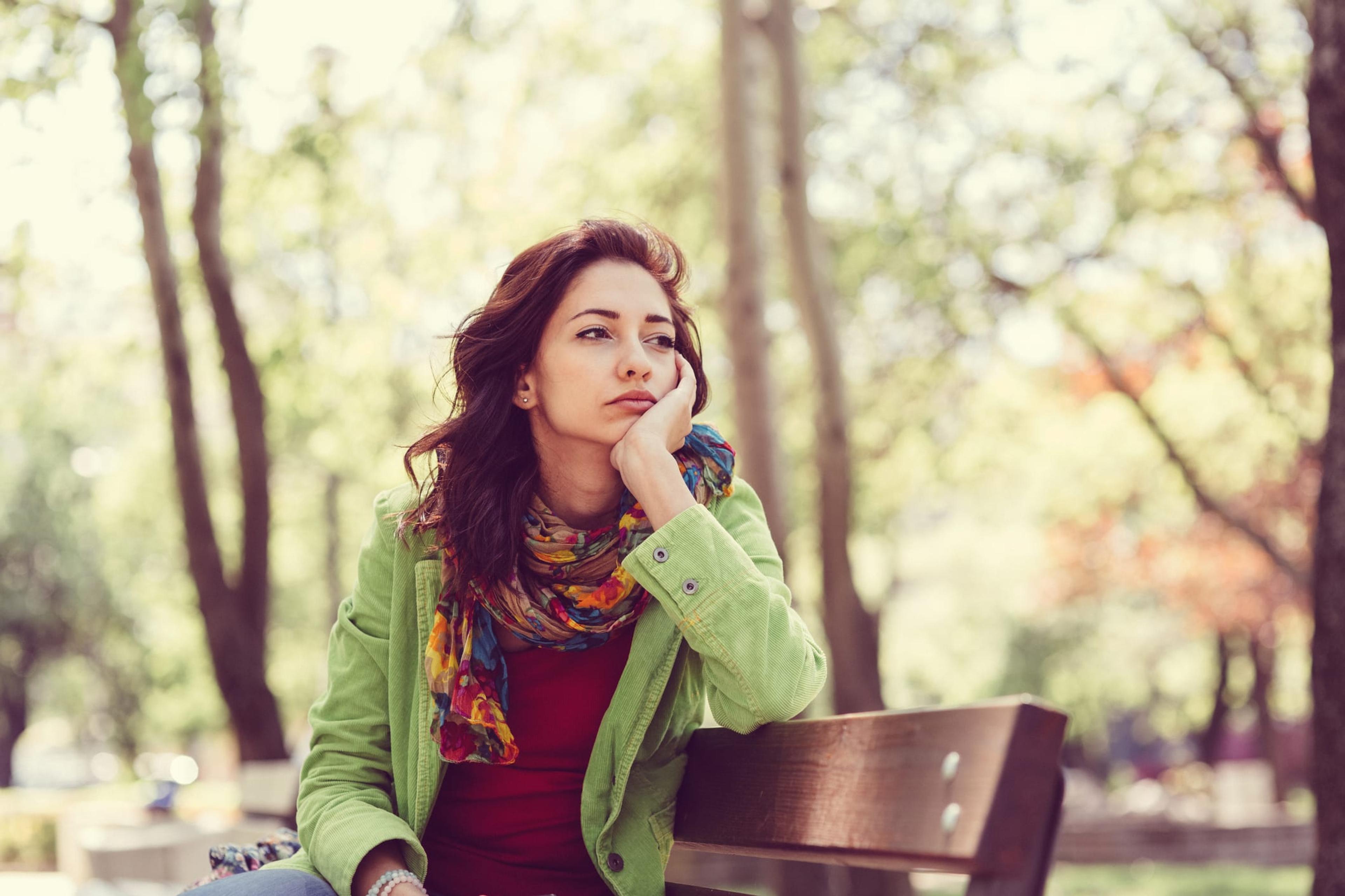 Woman sitting a bench in the park alone