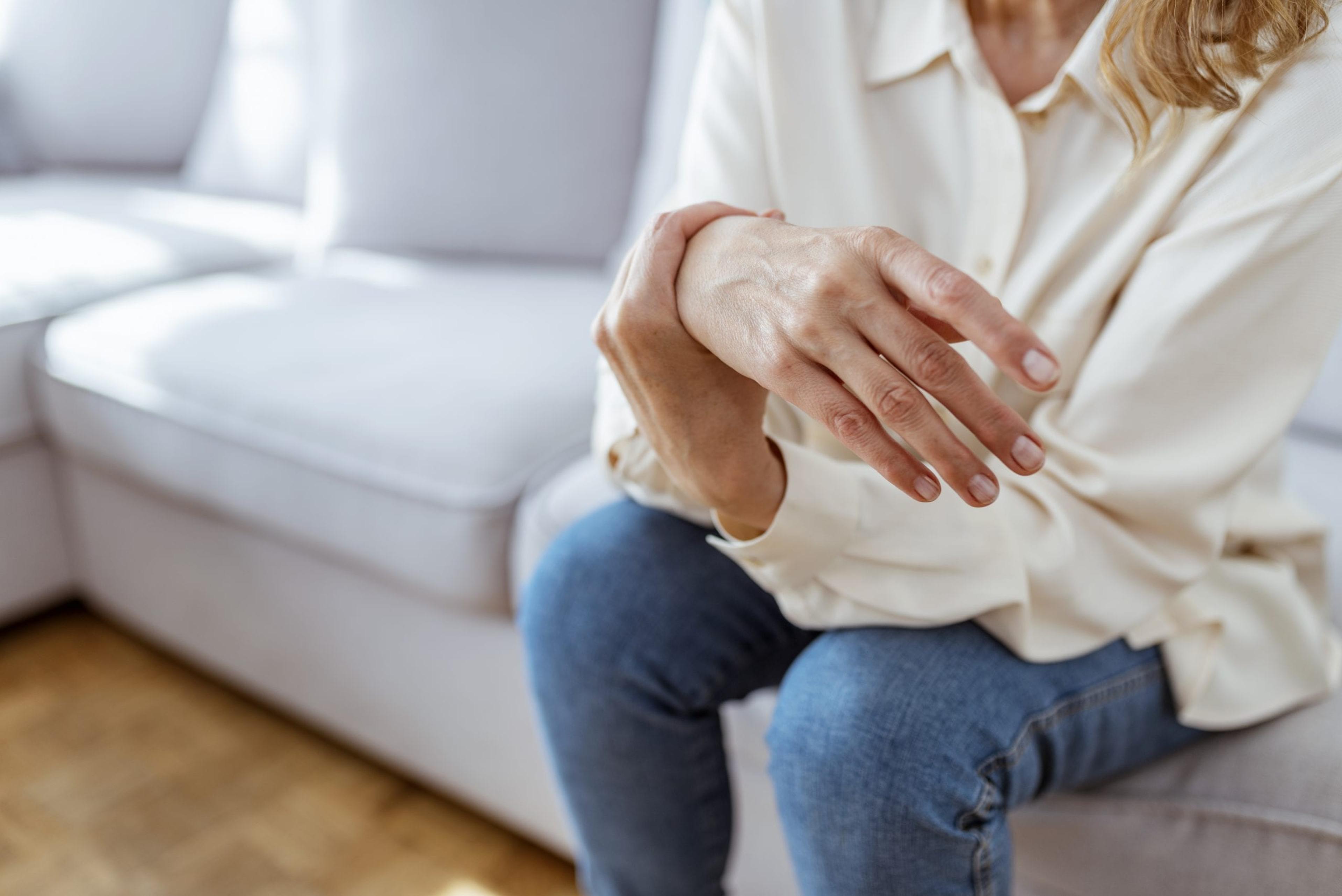 Photo of Elderly lady is enduring strong ache while sitting on the sofa during the day. Senior Woman At Home Suffering With Arthritis. Upset stressed mature middle-aged woman feeling pain ache.