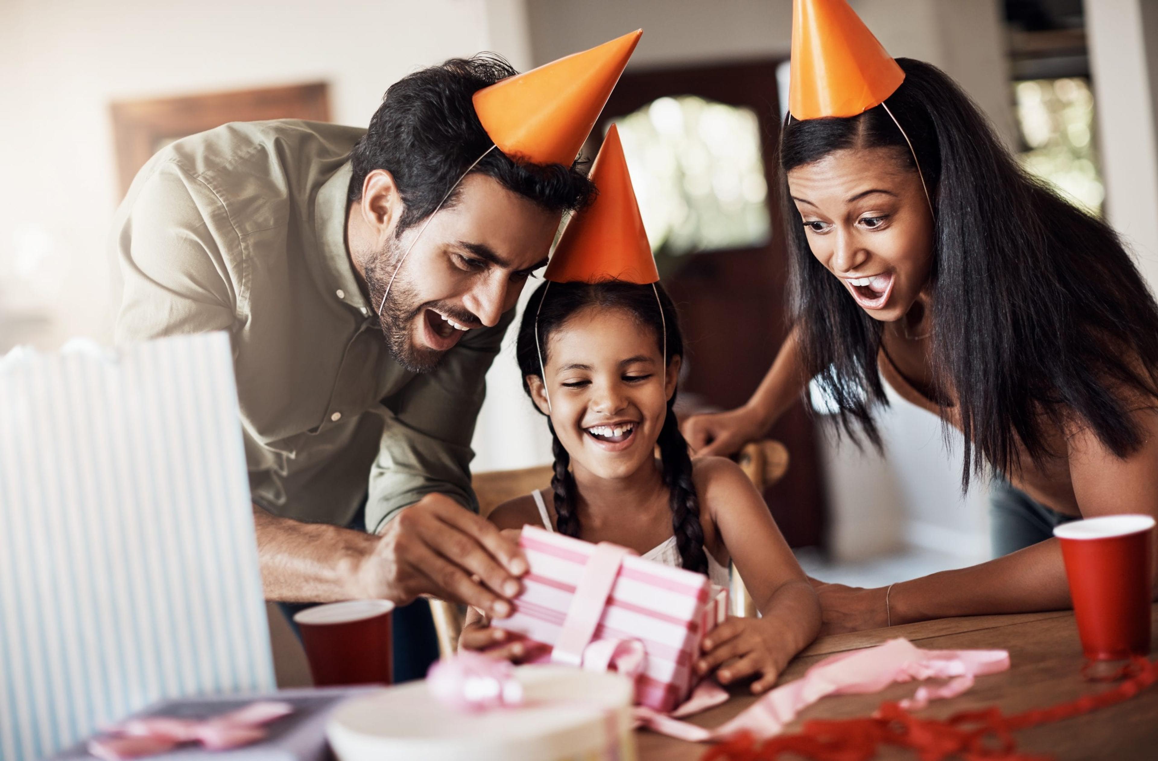 Family celebrating a little girl's birthday party.