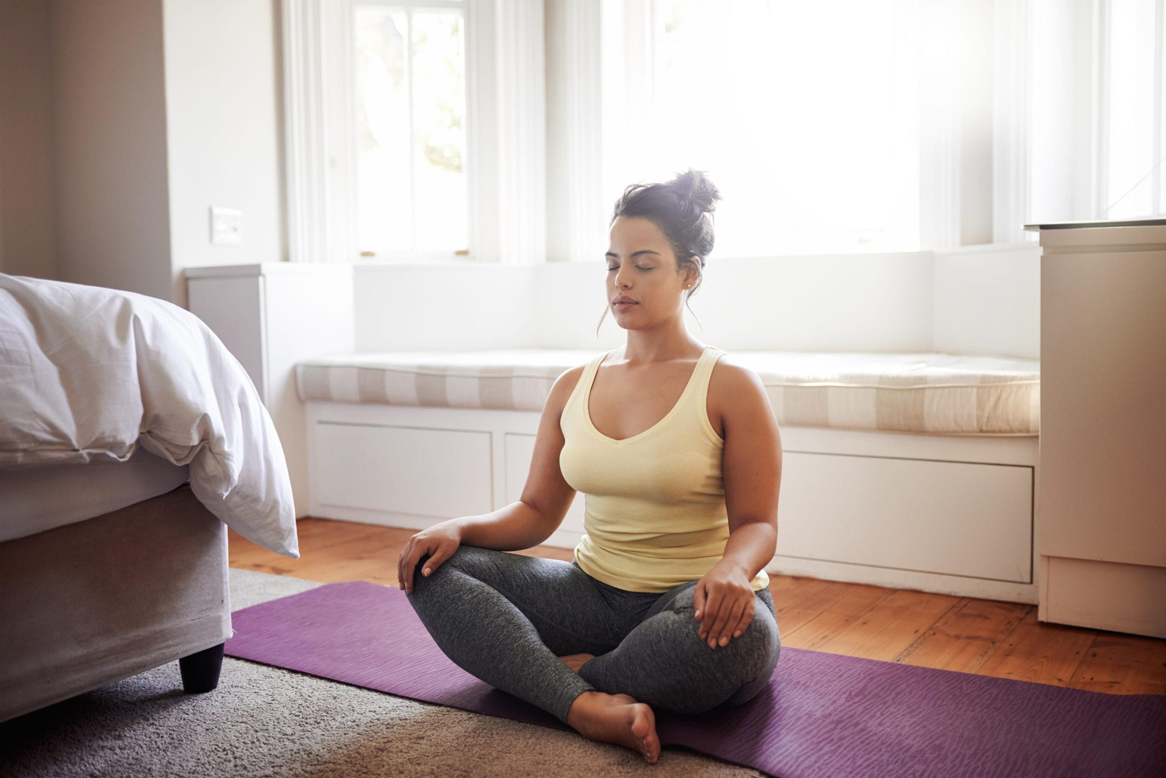 Young woman doing yoga in her room.