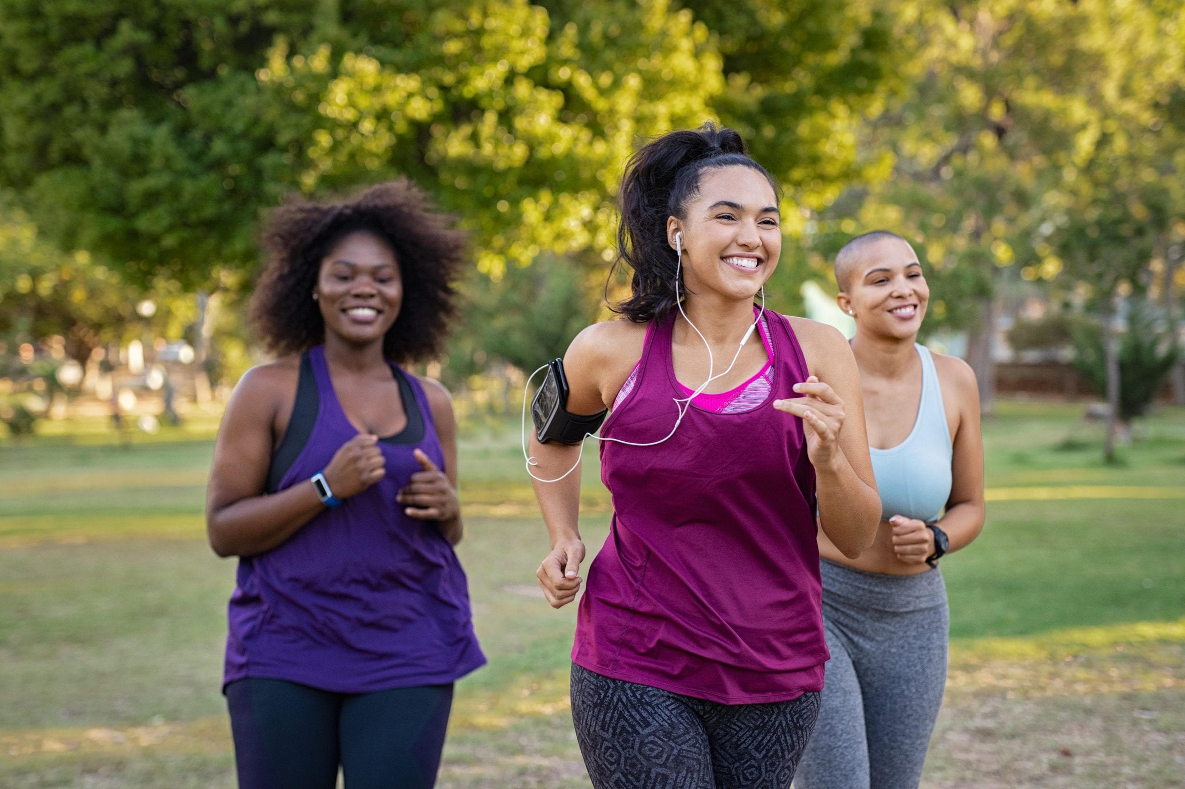 Smiling young women running at the park on a sunny day