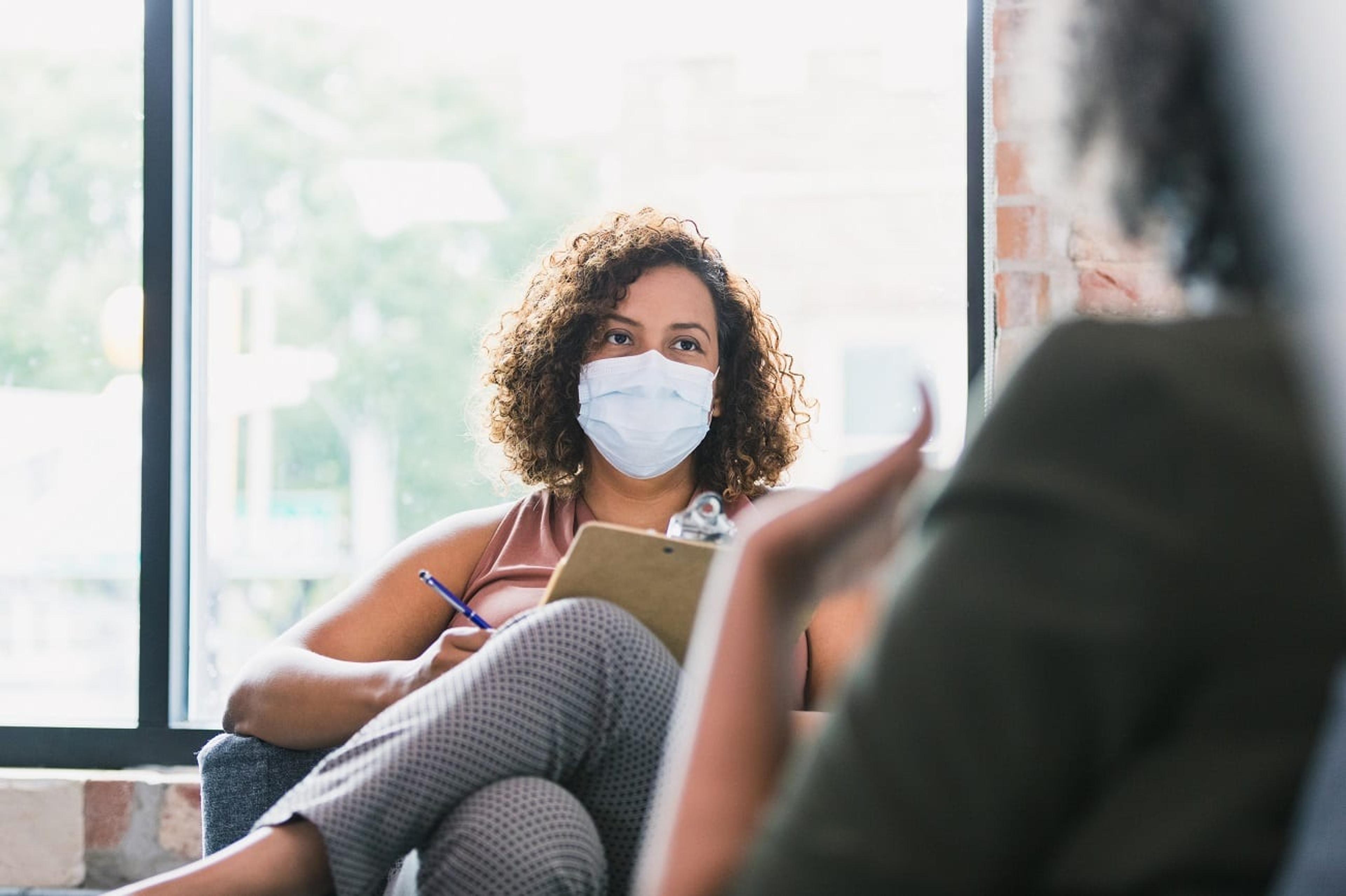 Female therapist wears mask during session