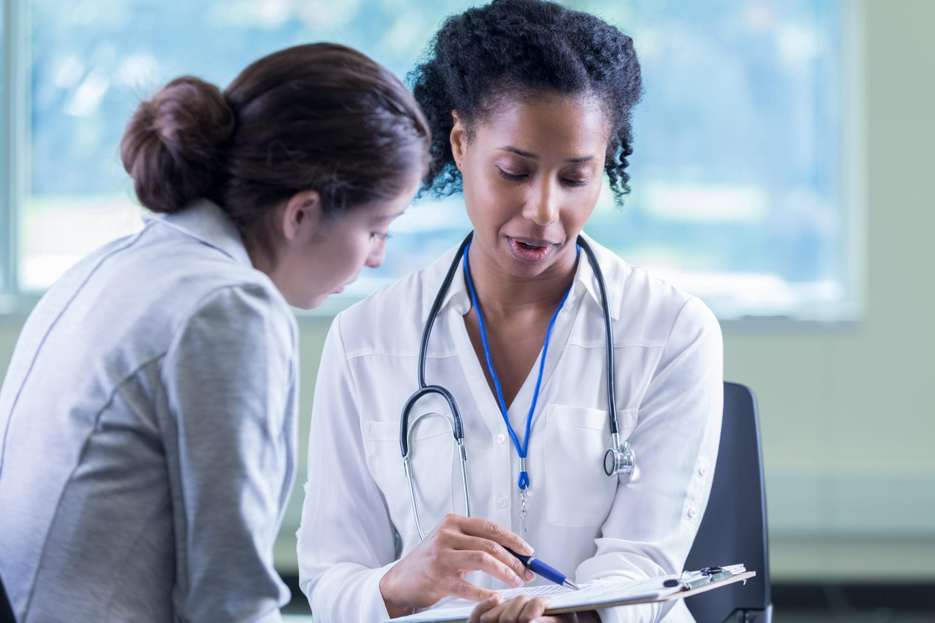 female doctor and female patient review medical documents