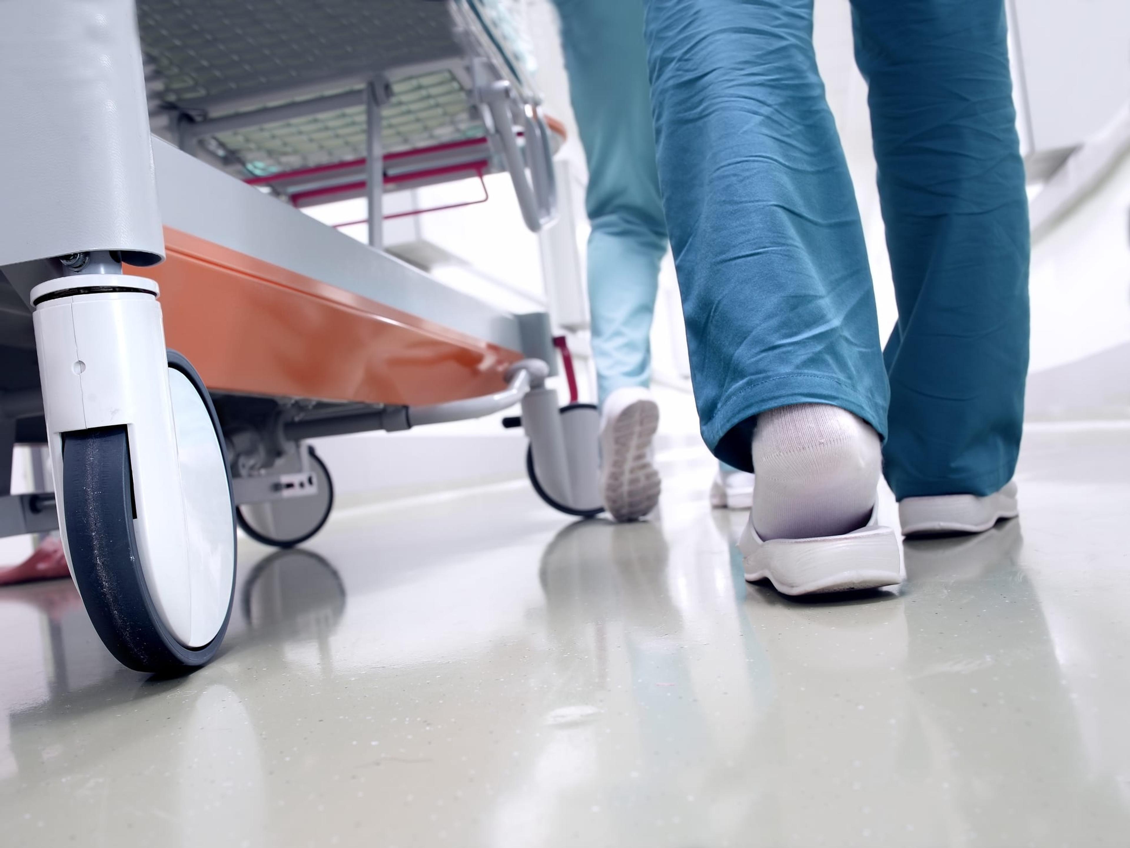 Image of medical staff moving a patient through hospital corridor.