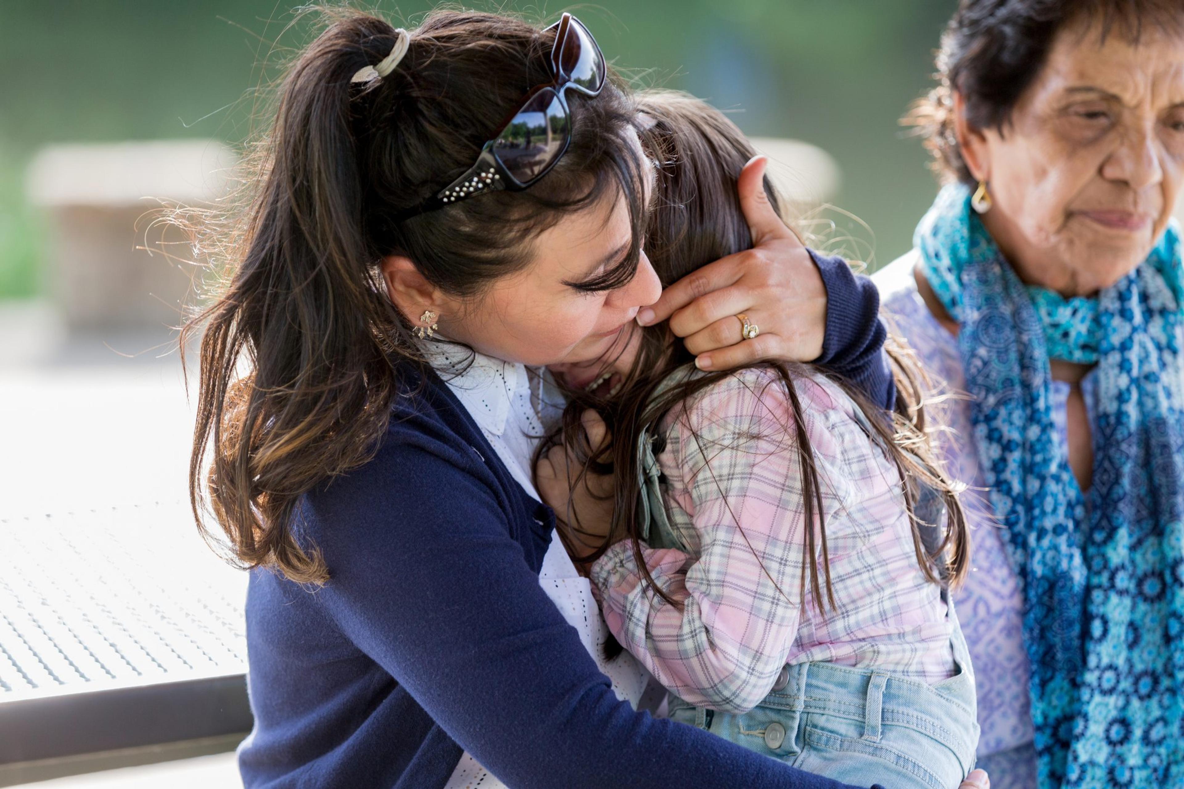 Crying little girl is comforted by a female adult