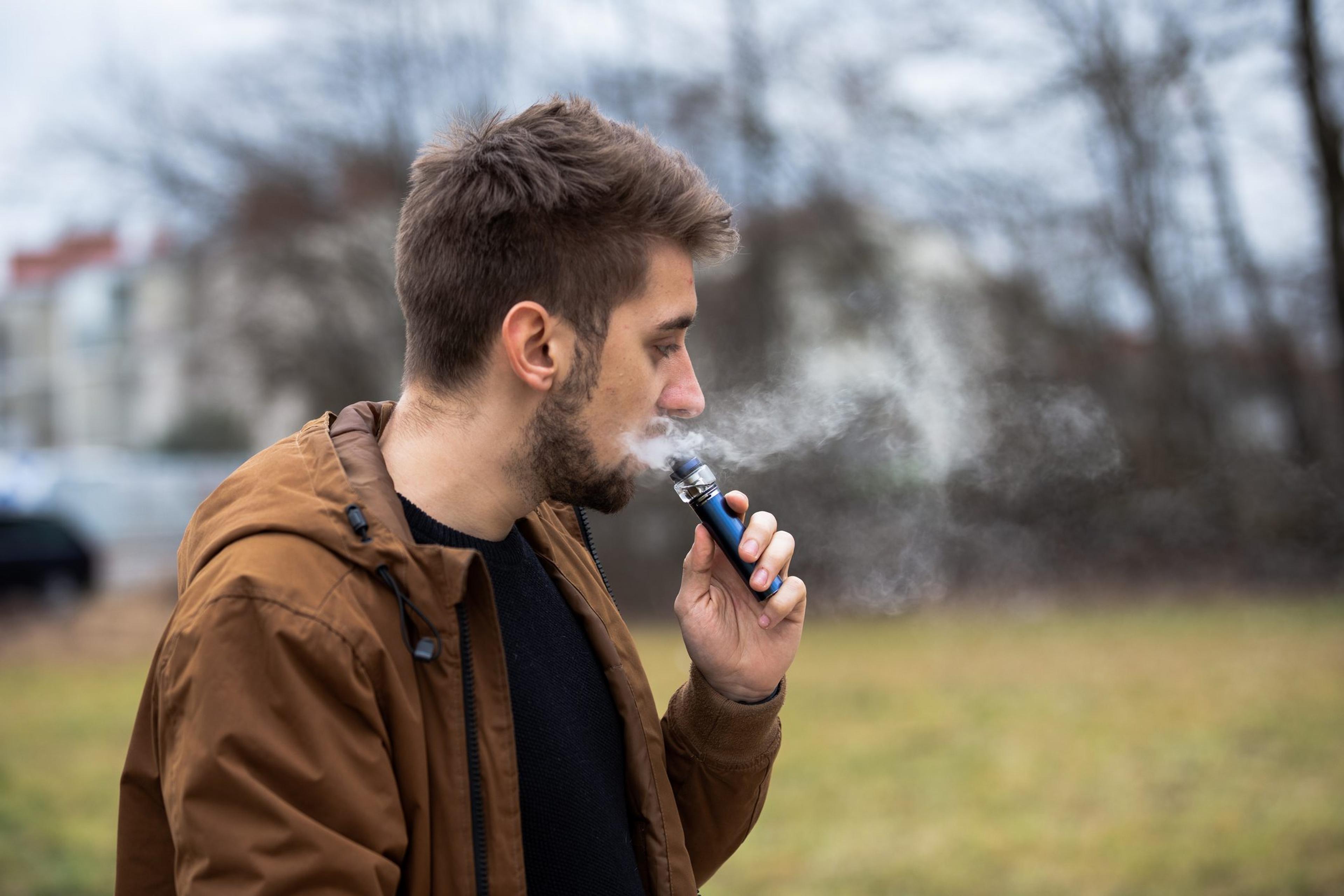 Young male worker smoking electronic cigarette