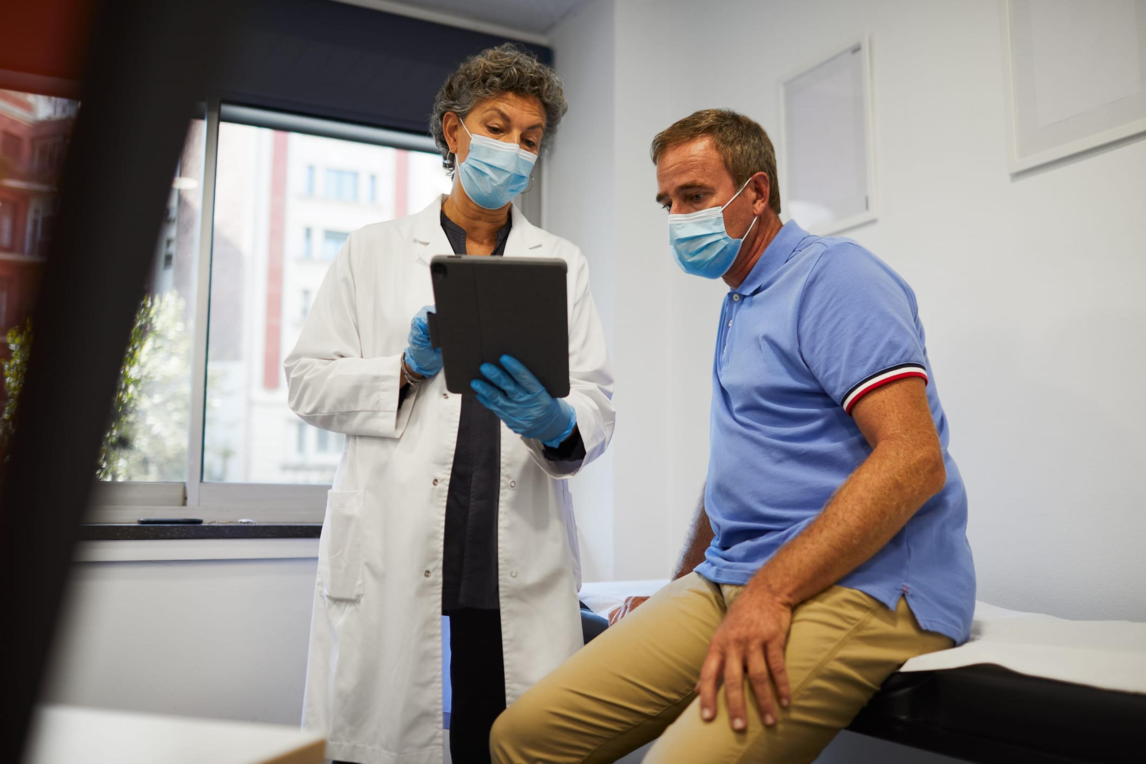 A doctor sharing medical results on a digital tablet with a patient.