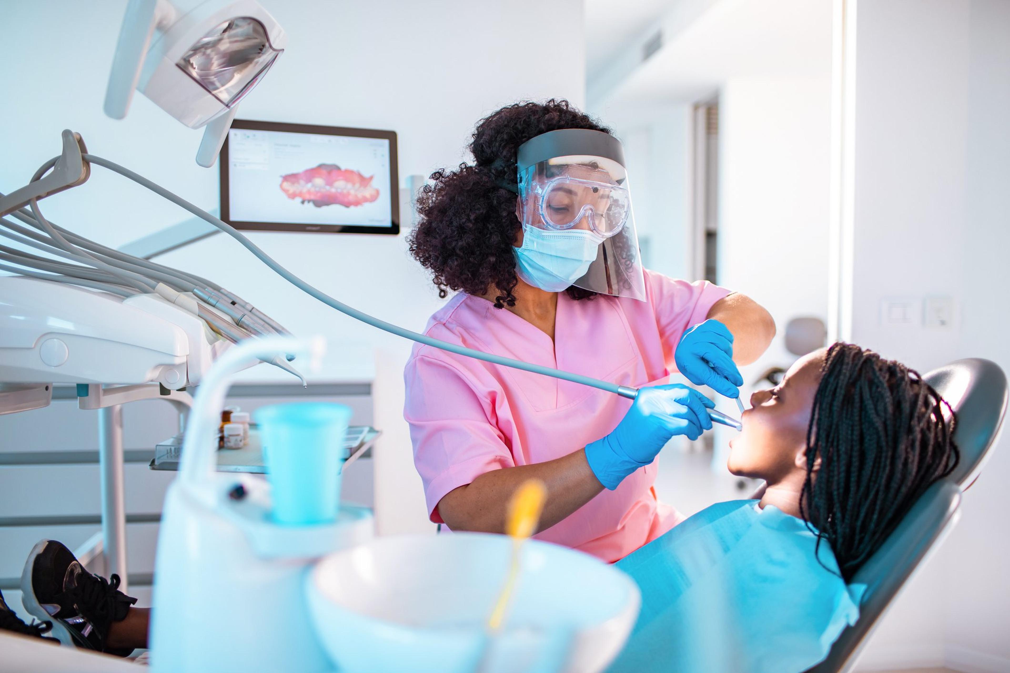 Young woman getting her teeth cleaned by a dentist