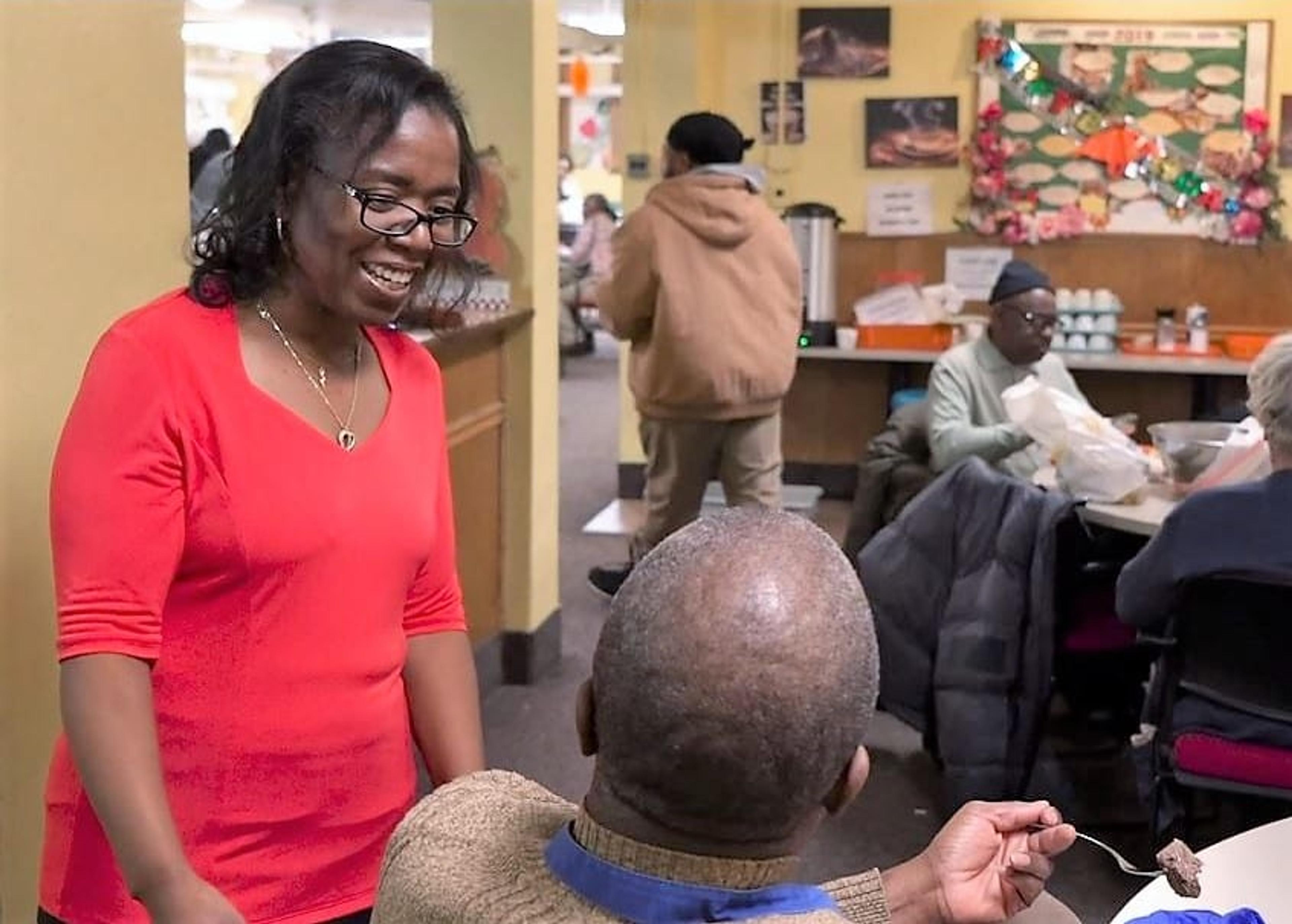 A woman speaks with senior citizens at a community center