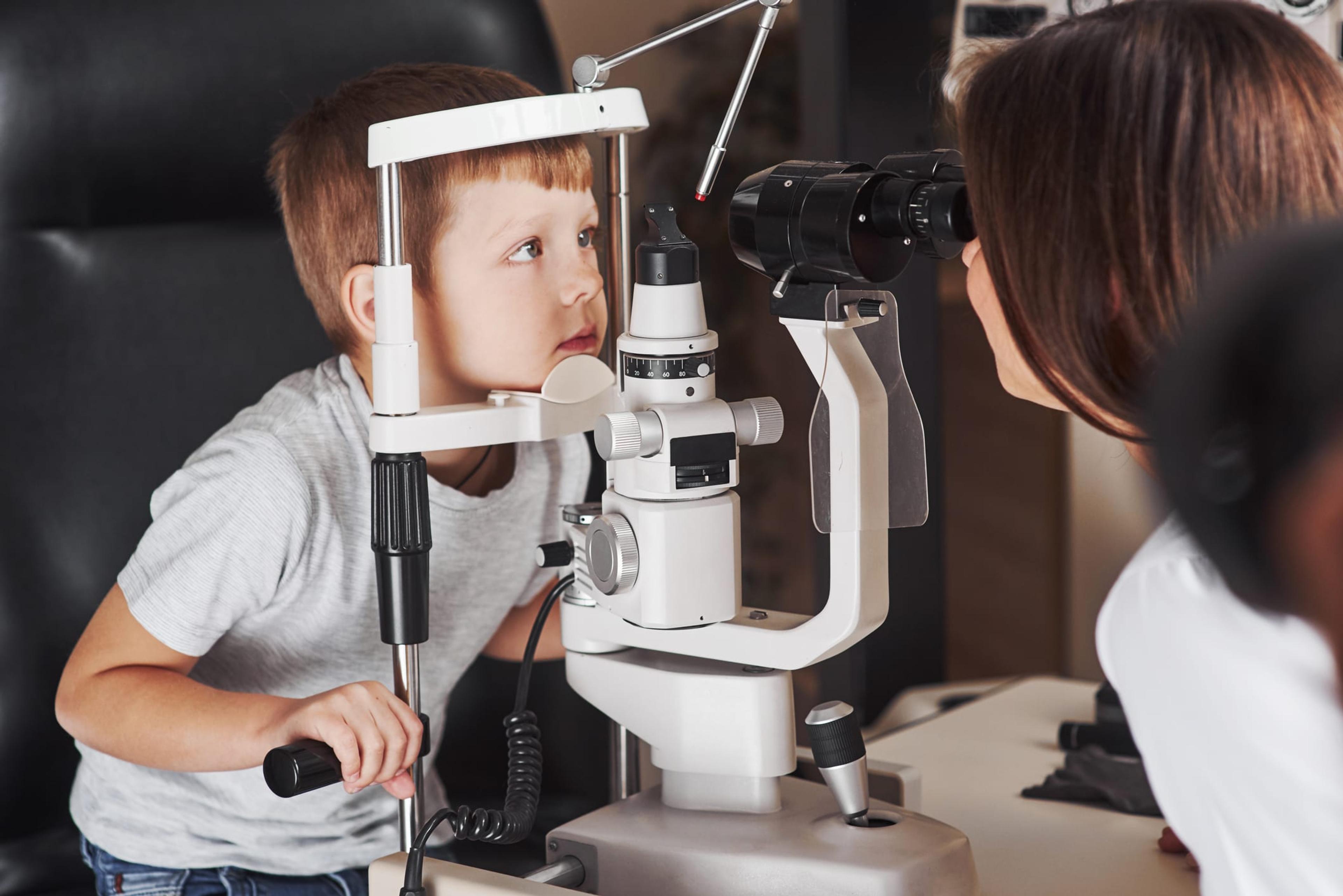 Little boy getting an eye exam by a female doctor.