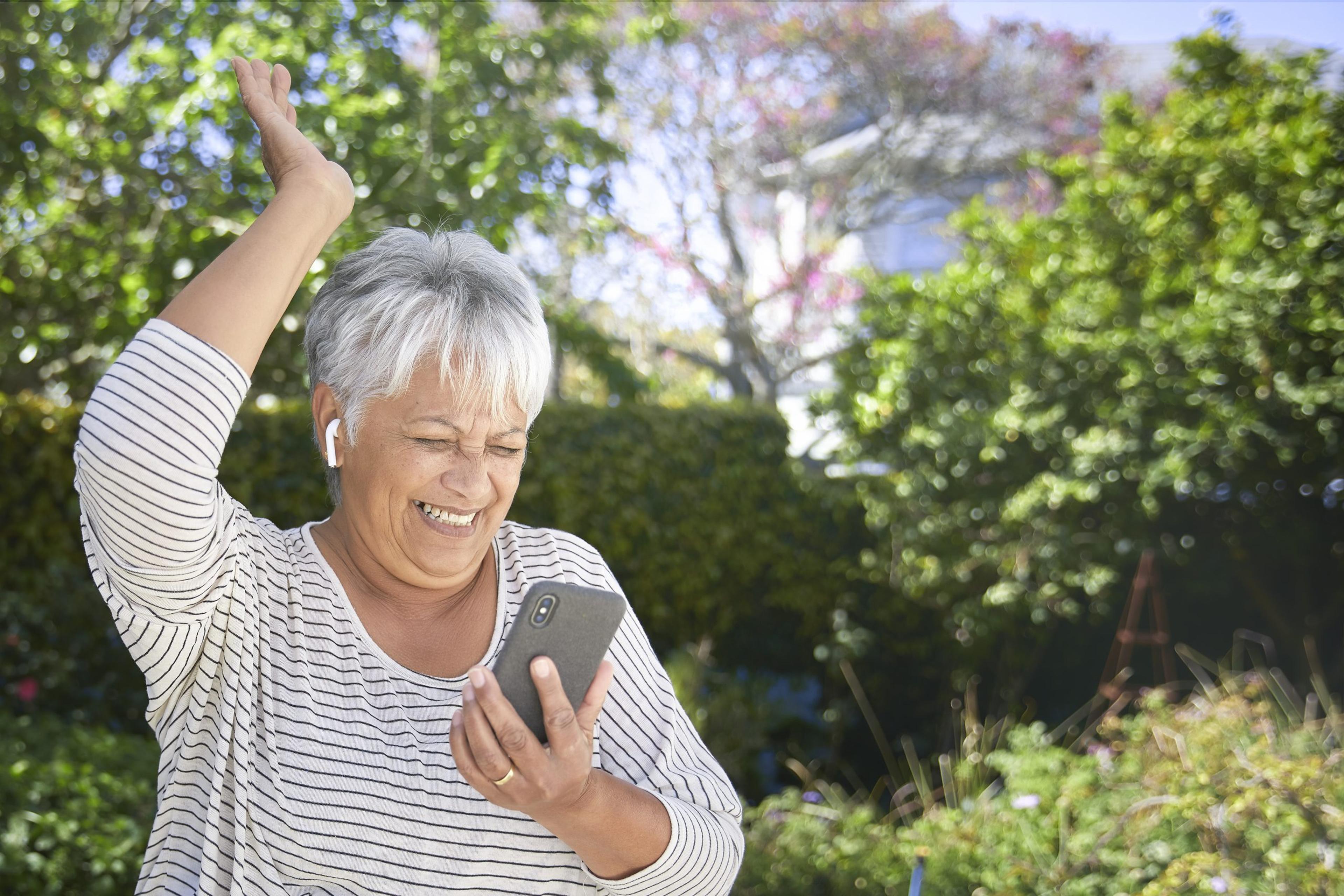 Happy senior woman dancing in her garden