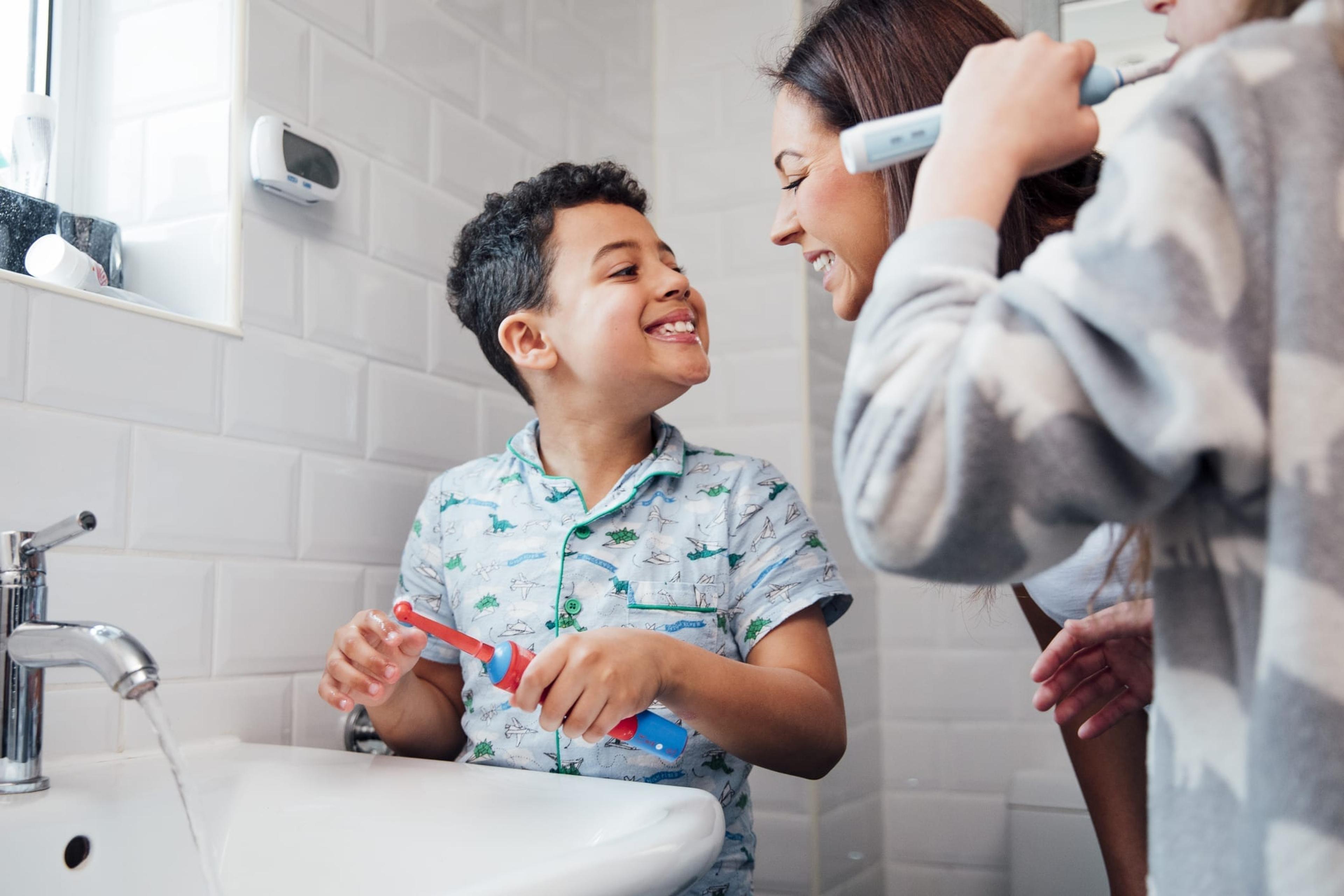 Boy smiling at woman after brushing his teeth
