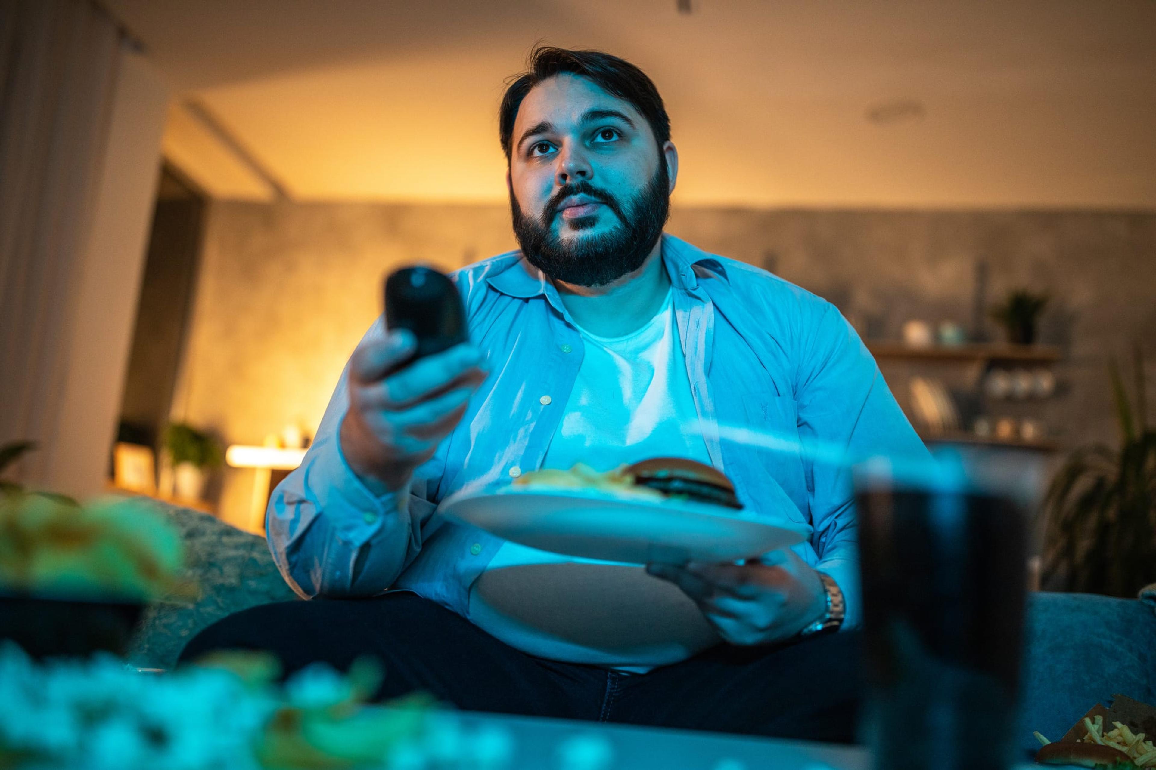 Man sitting in front of TV eating dinner