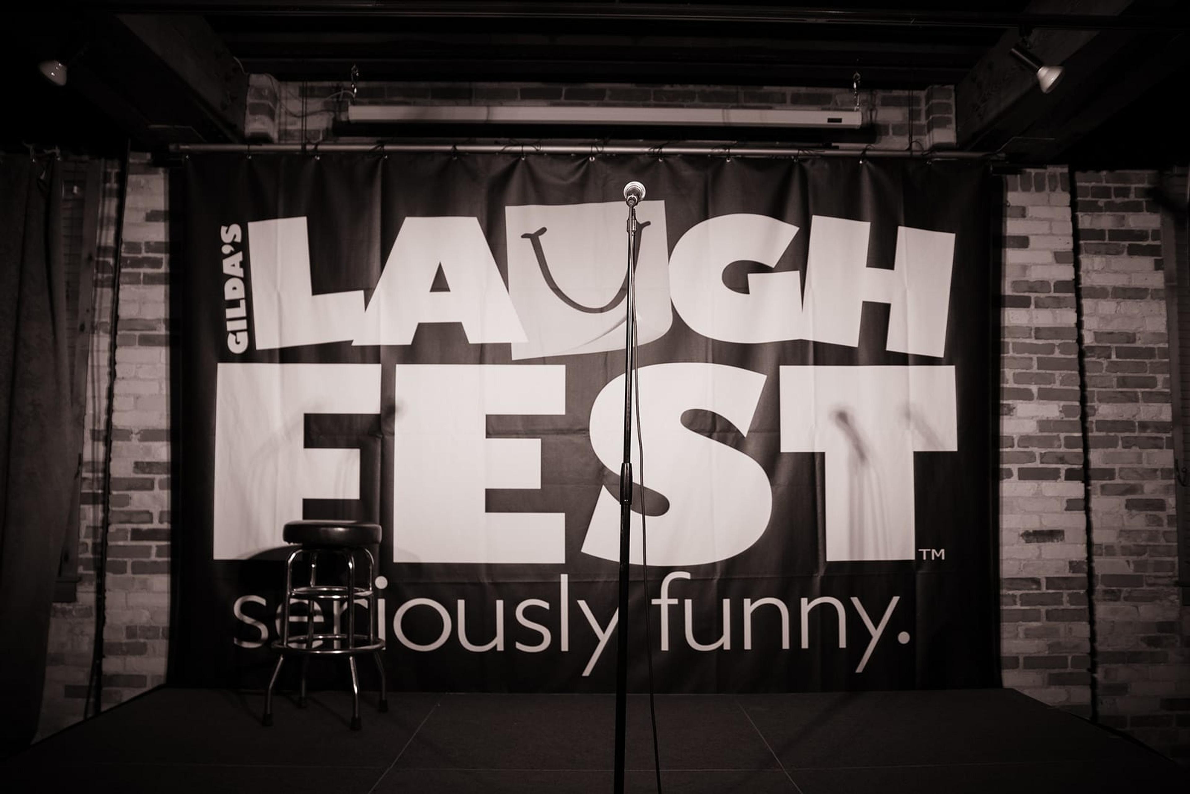LaughFest banner on a stage with a microphone in front