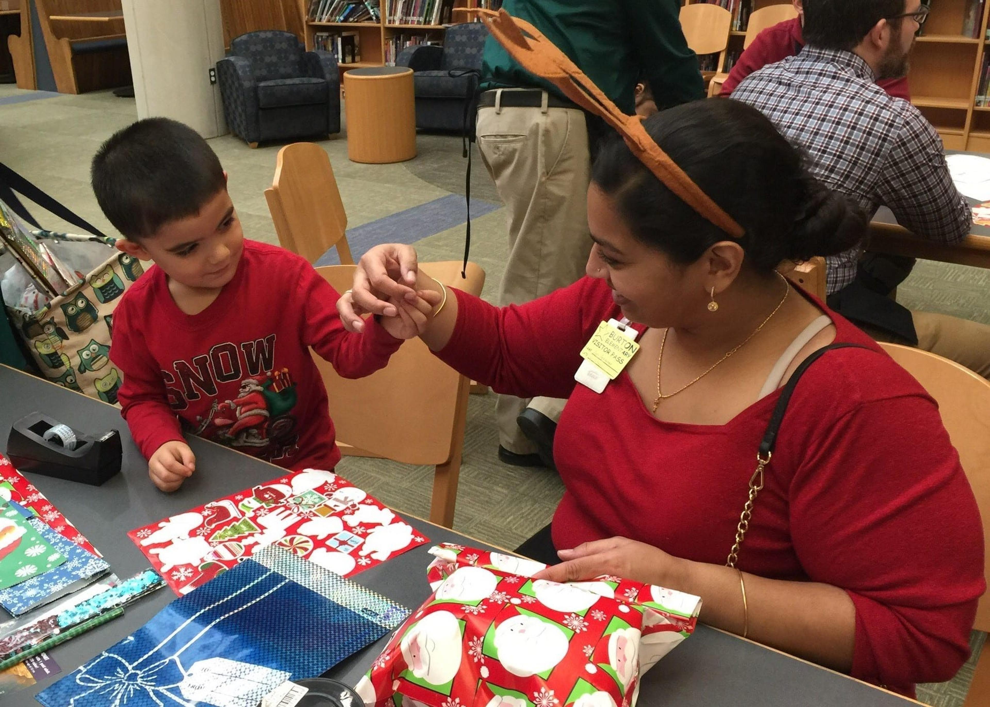 Amy Abraham helps a young shopper wrap his gifts.