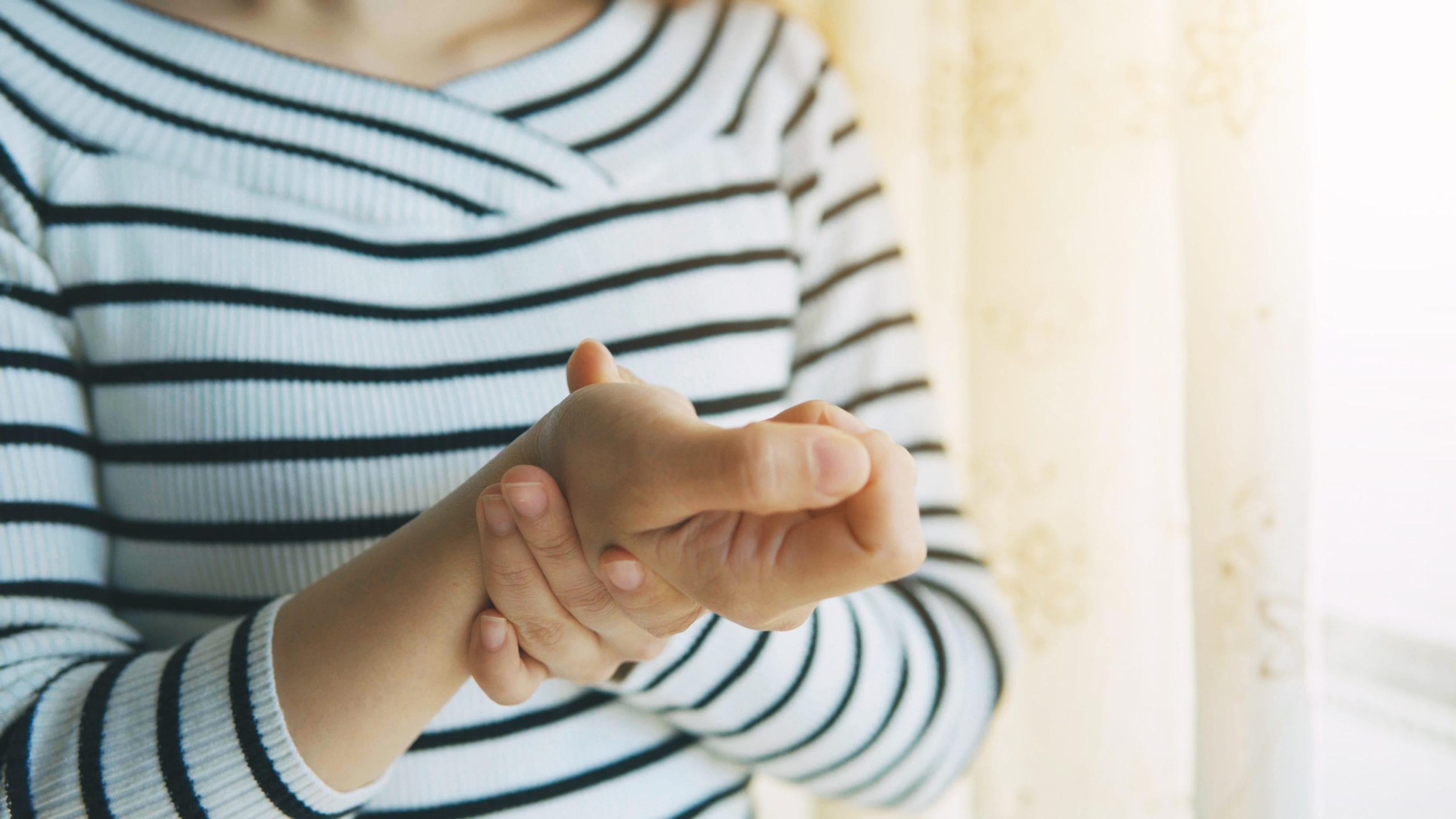 Woman massaging her arthritic hand and wrist.