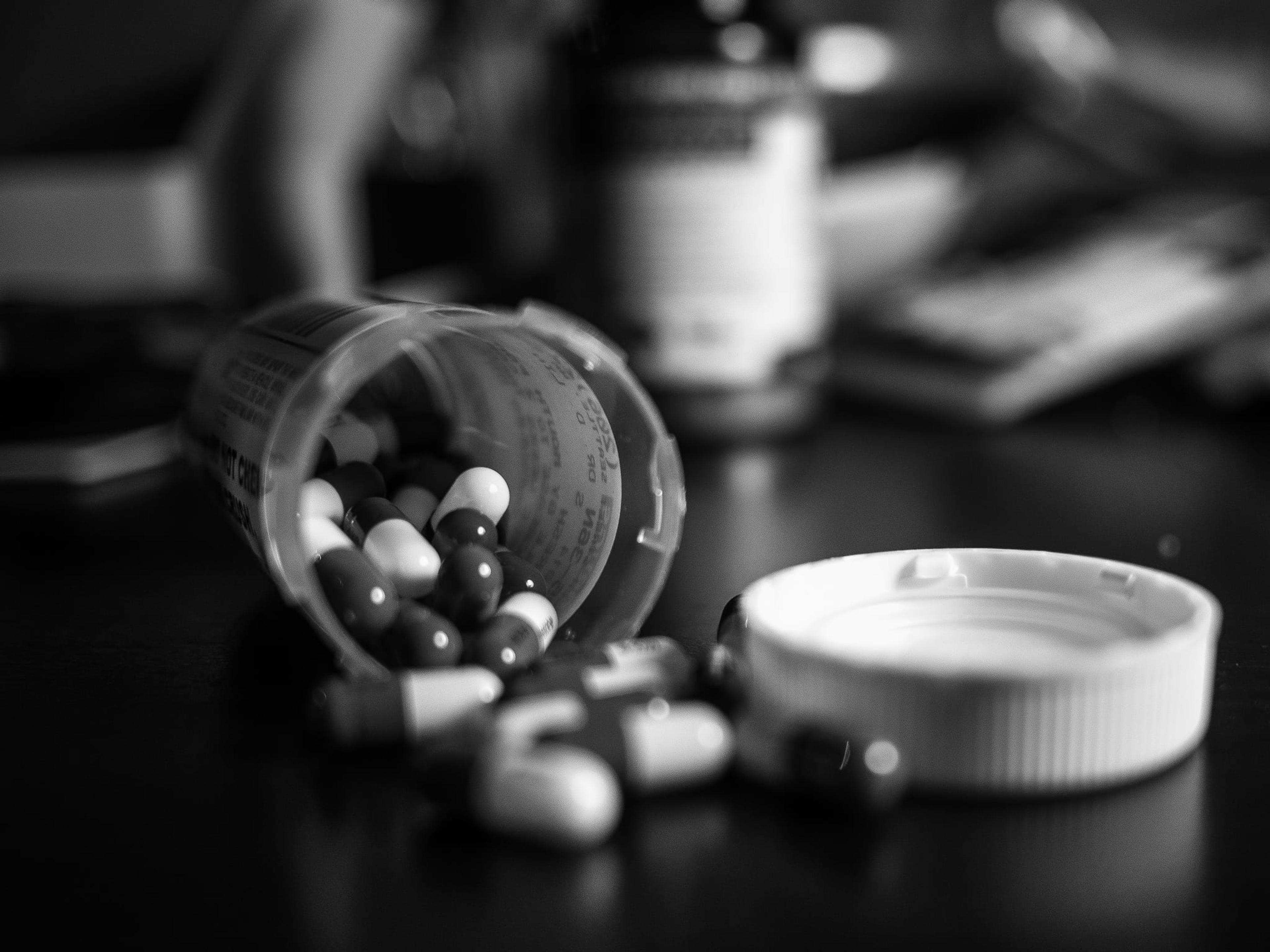 Black and white image of a prescription bottle tipped on its side.