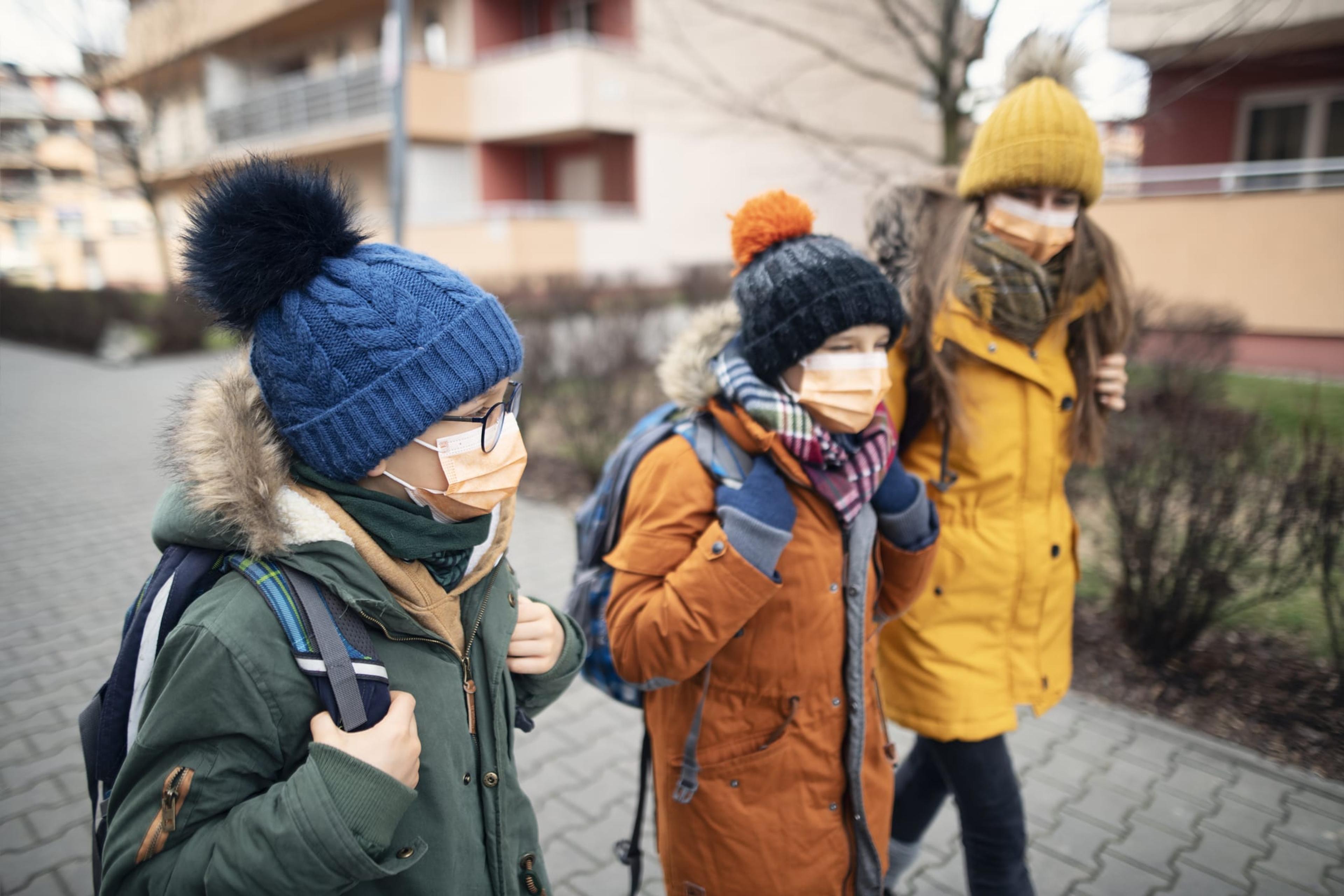 Family walking while wearing masks