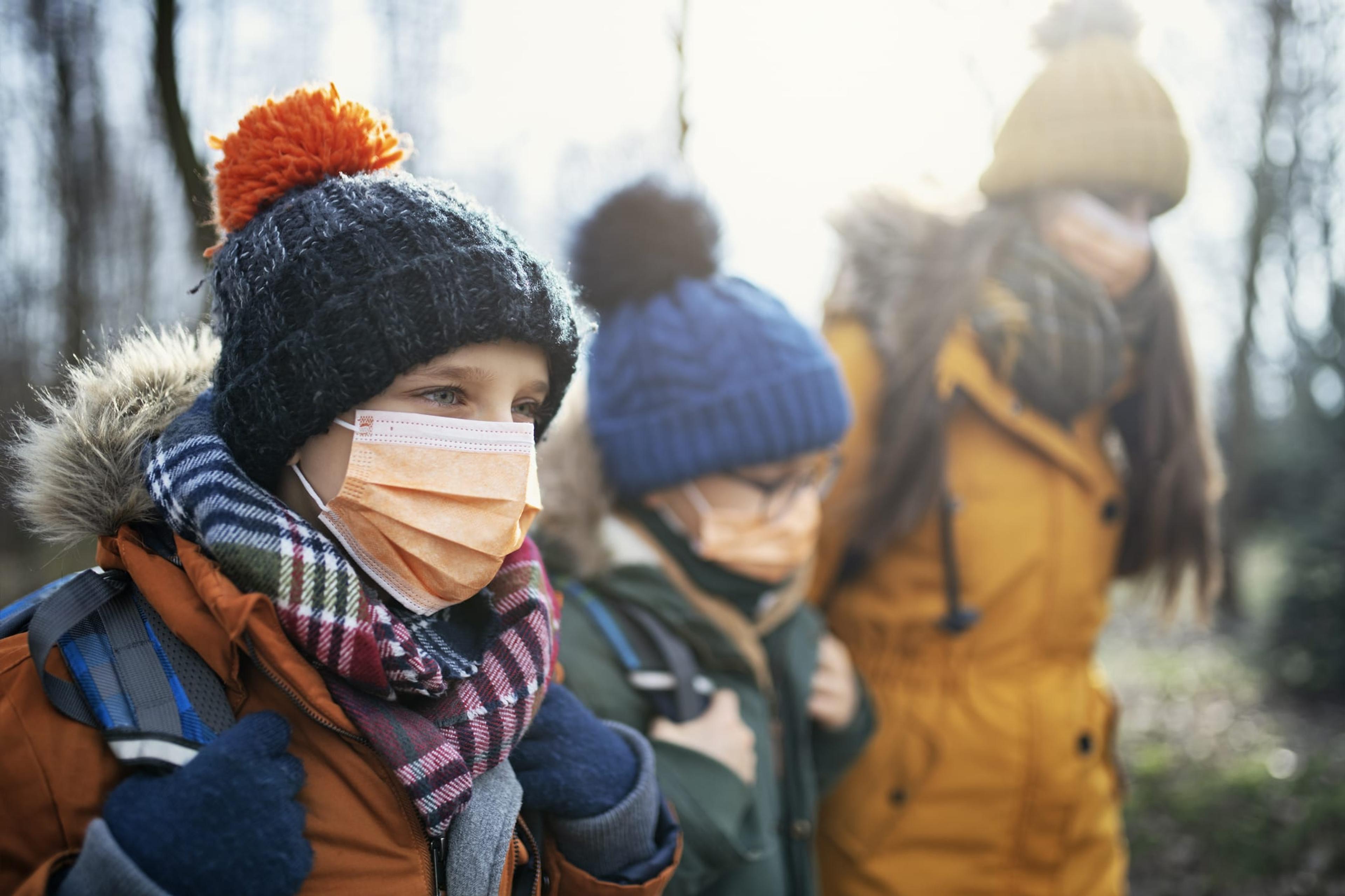 Children in the cold wearing masks