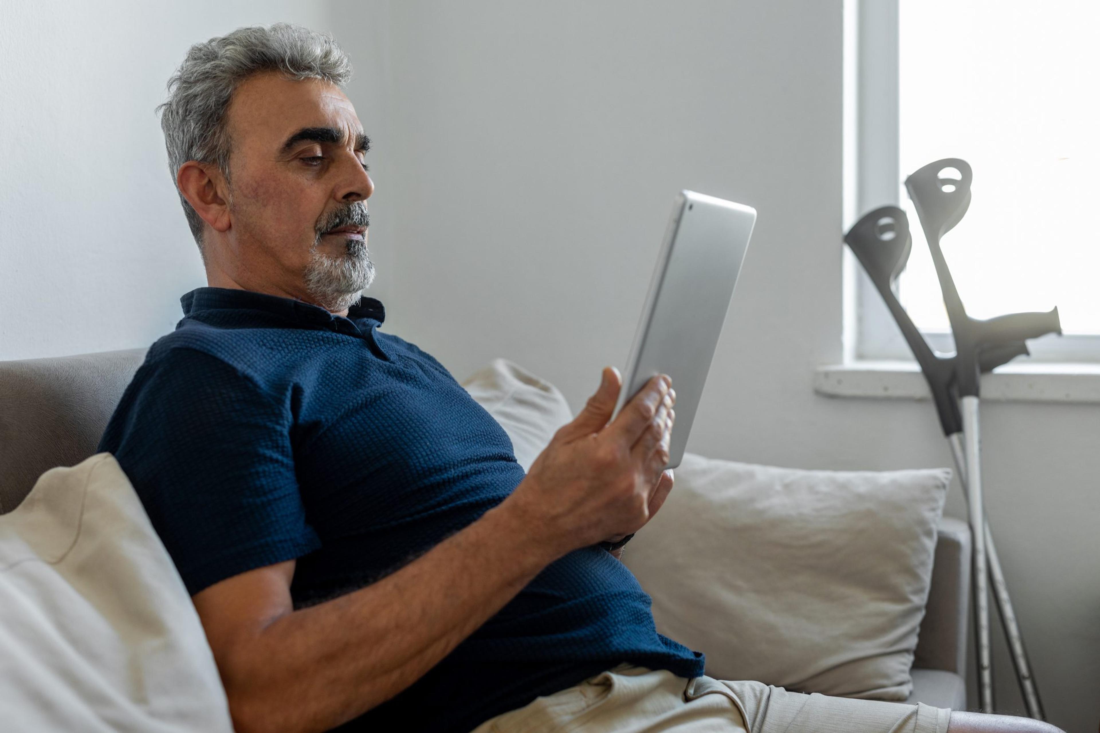 Old man with broken leg at home does a telehealth visit