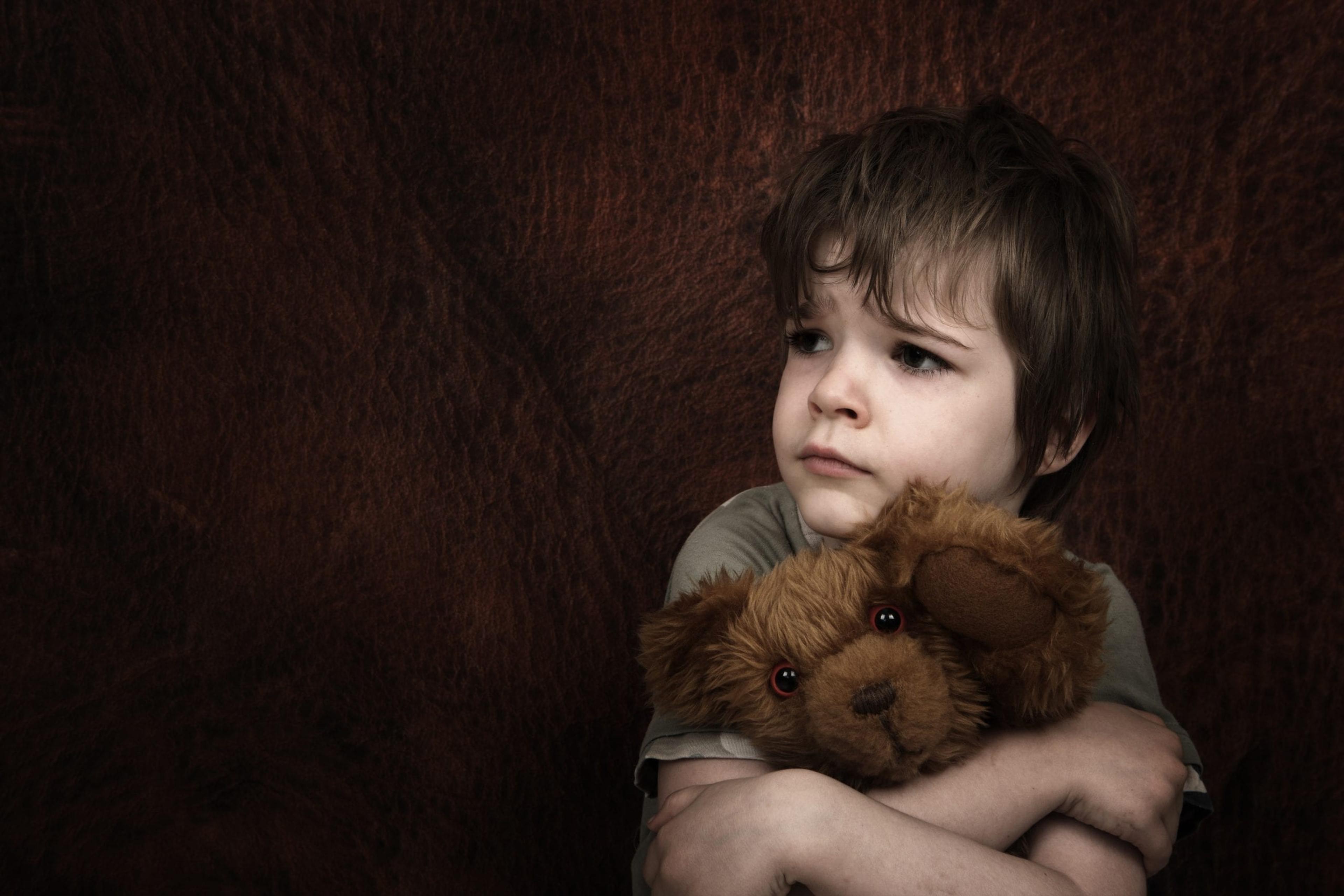 Worried child holdinig a teddy bear