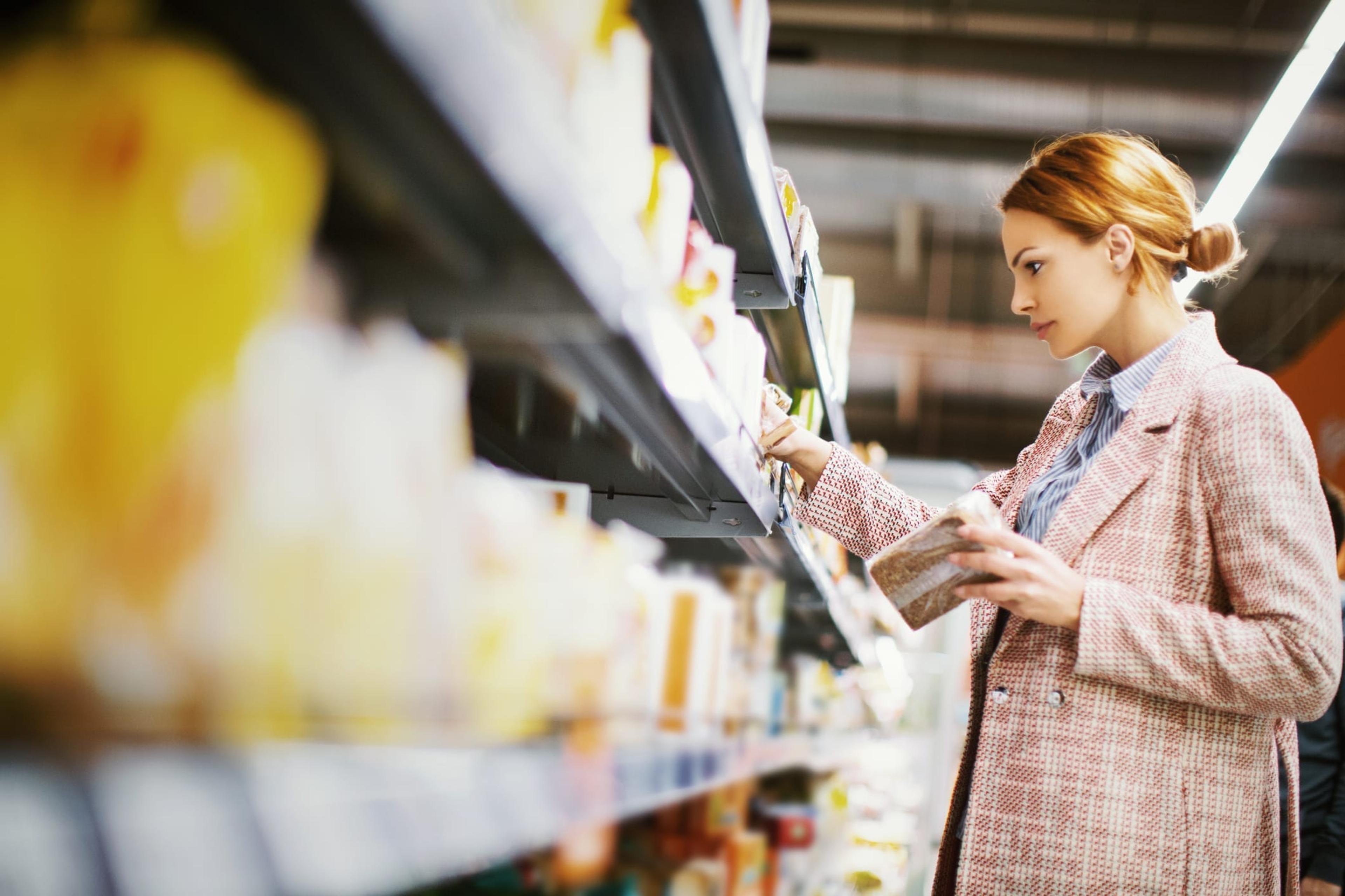 Woman searching for products on grocery store shelves