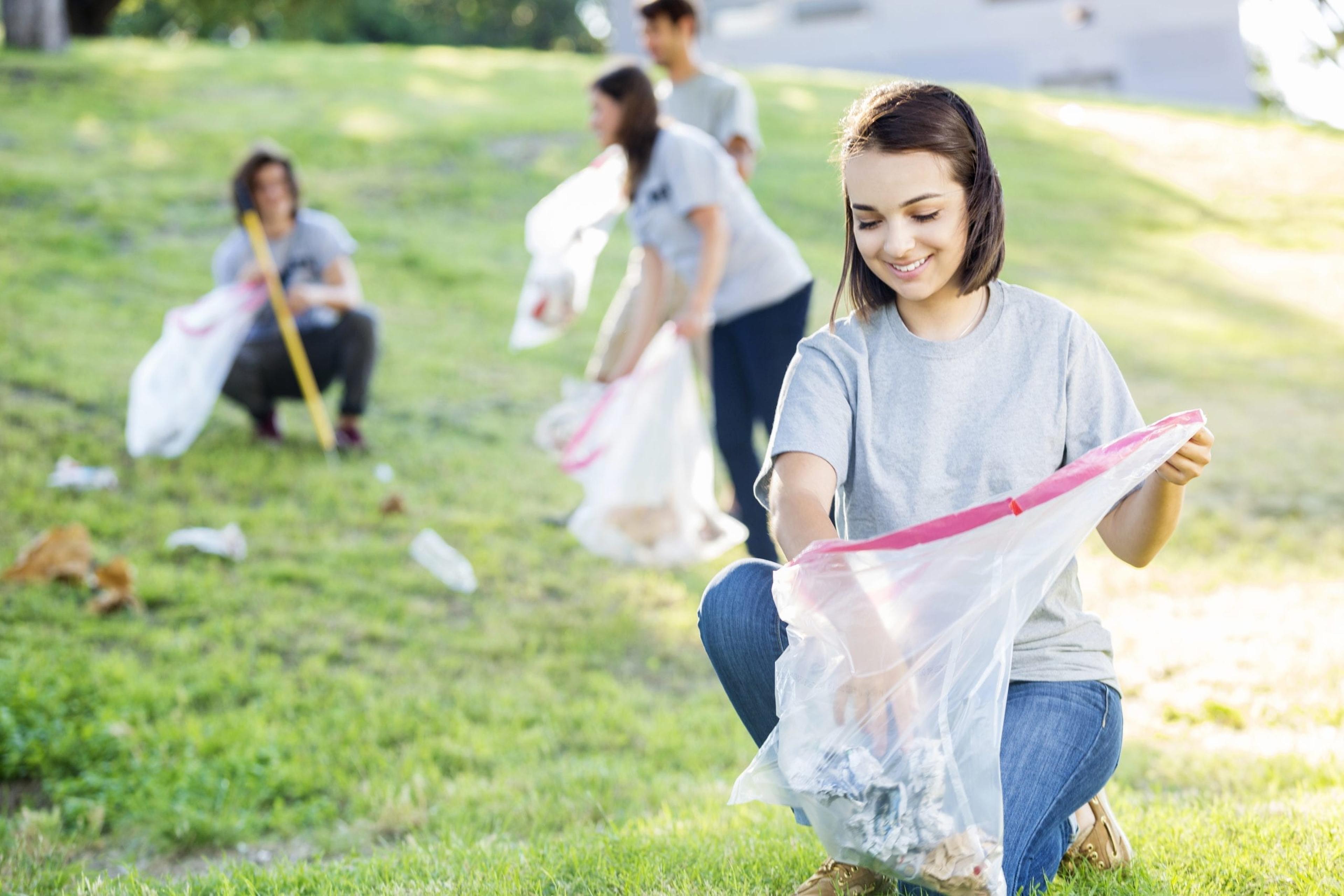 Young woman cleaning up a park.